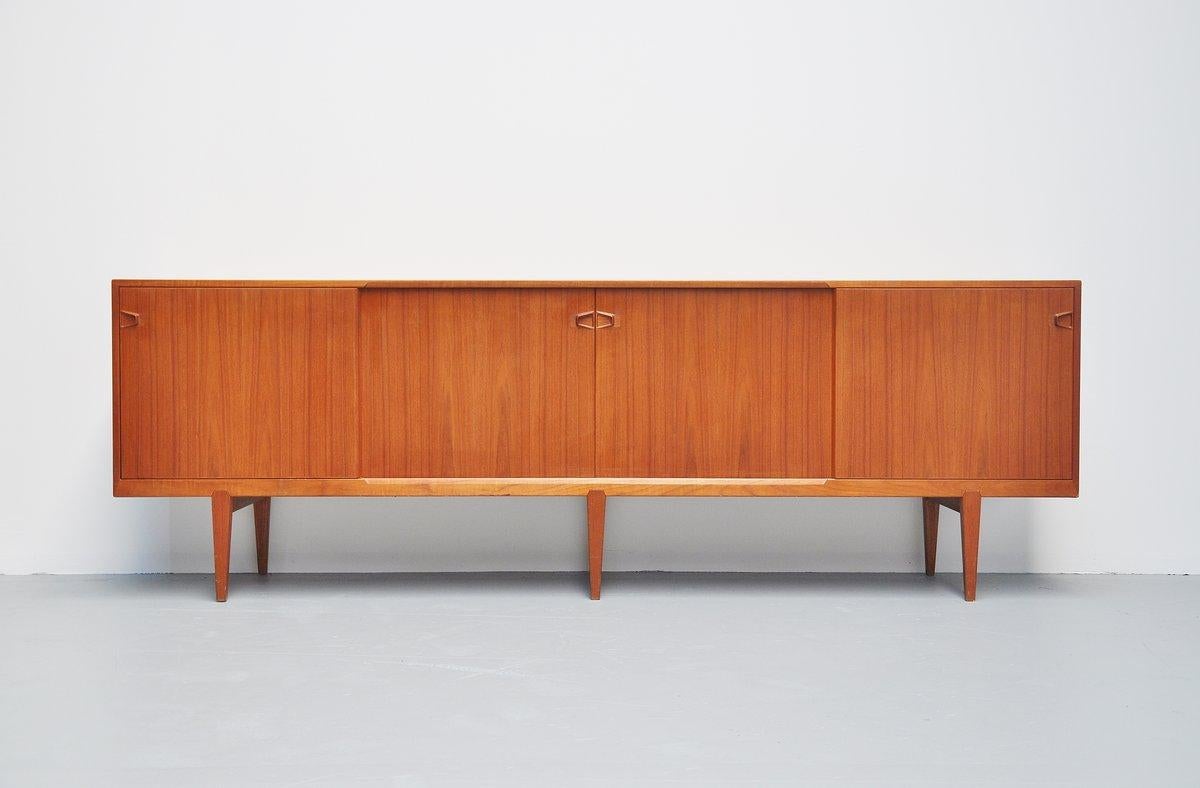 Nicely refined sideboard model 9940 designed by Henry Rosengren Hansen for Rosengren Hansen, Denmark, 1960. The sideboard has 4 sliding doors with shelves and 4 drawers behind. Very nice crafted tea handles and a nice detail is the way the legs are