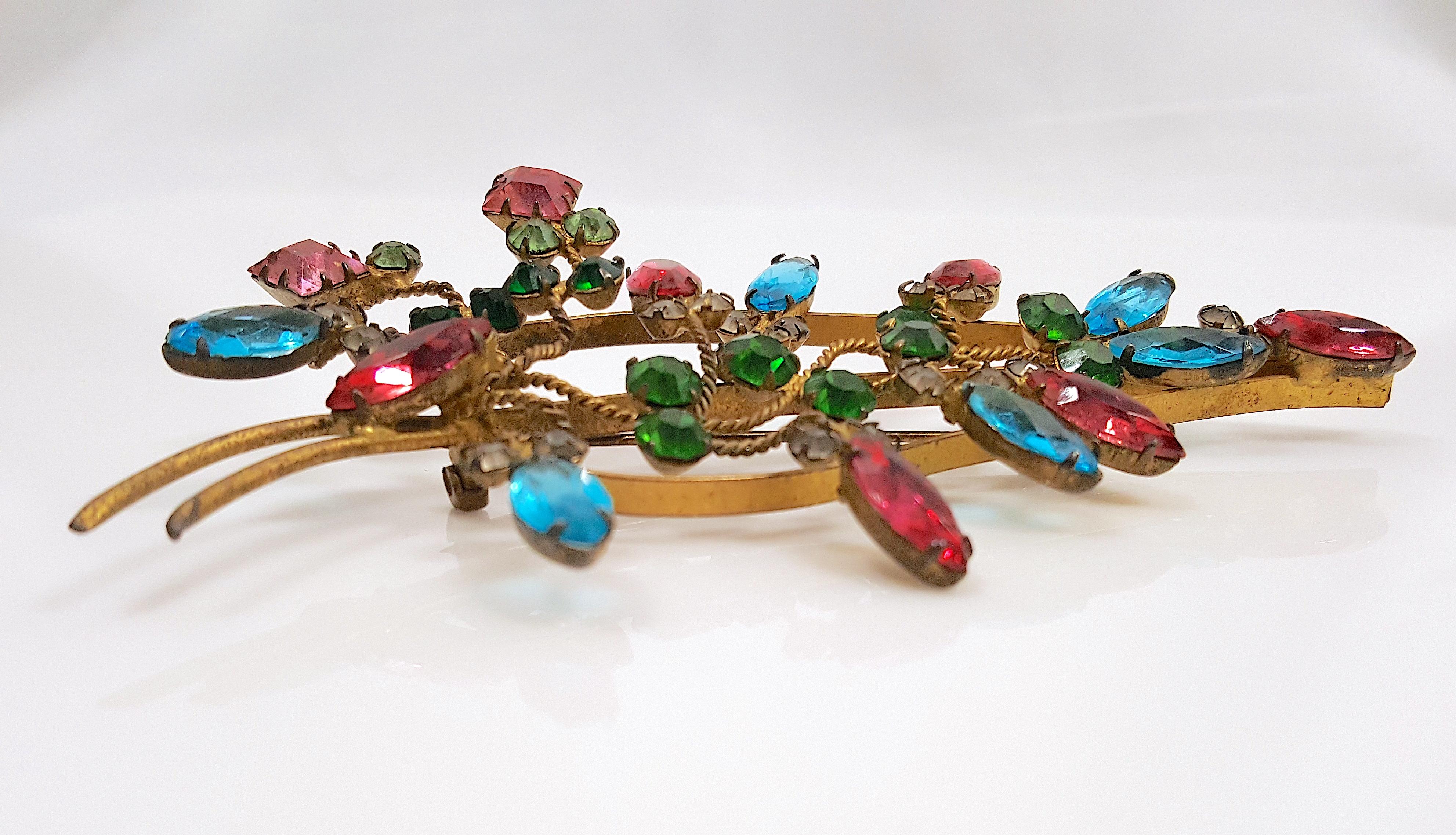 Henry Schreiner, the Austrian-born blacksmith founder of Schreiner New York in 1932, handcrafted this multi-color prong-set Bavarian crystal stylized-flora spray gold-gilt brass brooch before he began designing more extravagant silver-soldered