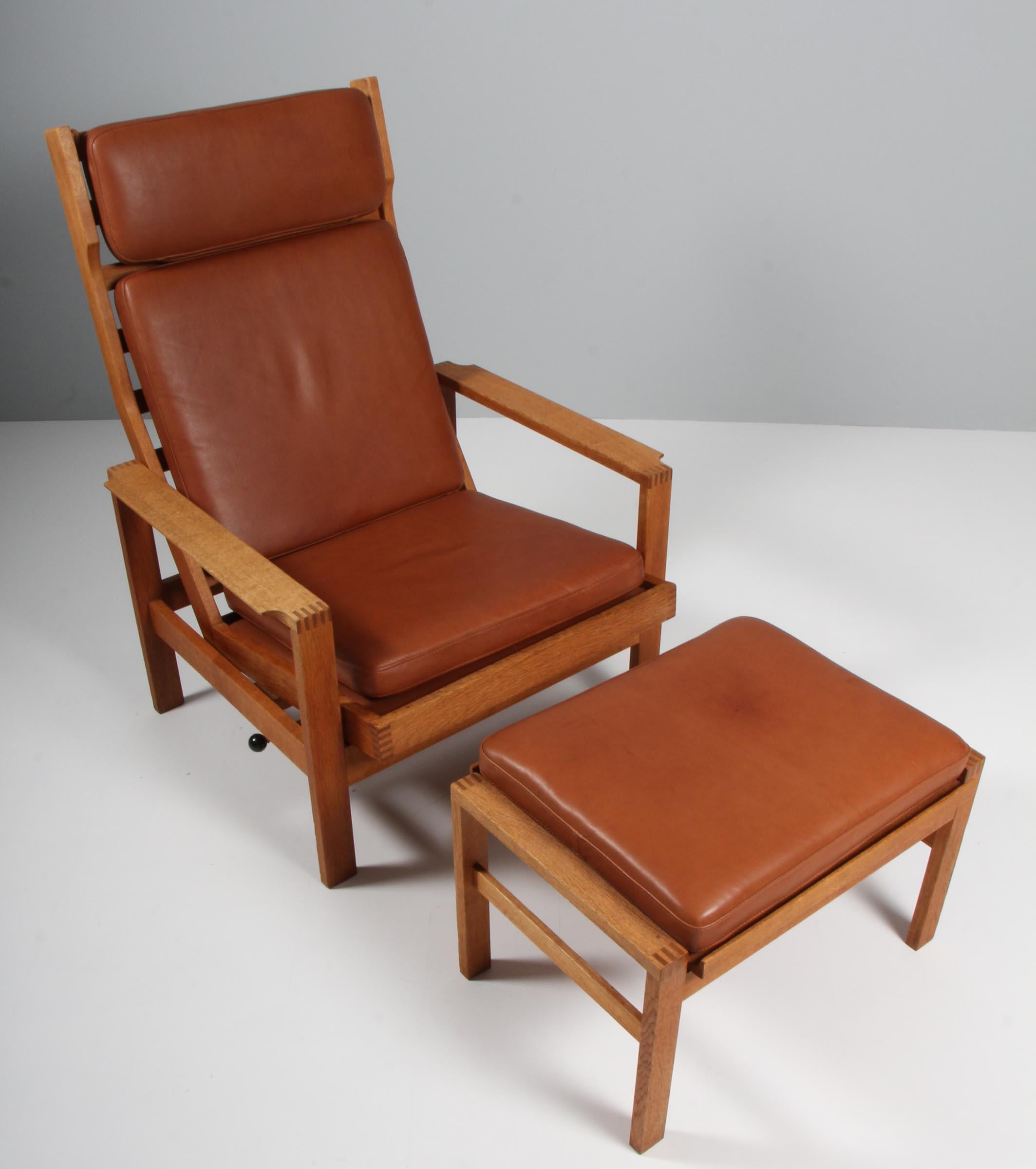 Madsen & Schubell lounge chair with ottoman. Upholstered with red wool.

Frame of teak.

Made by Madsen & Schubell.