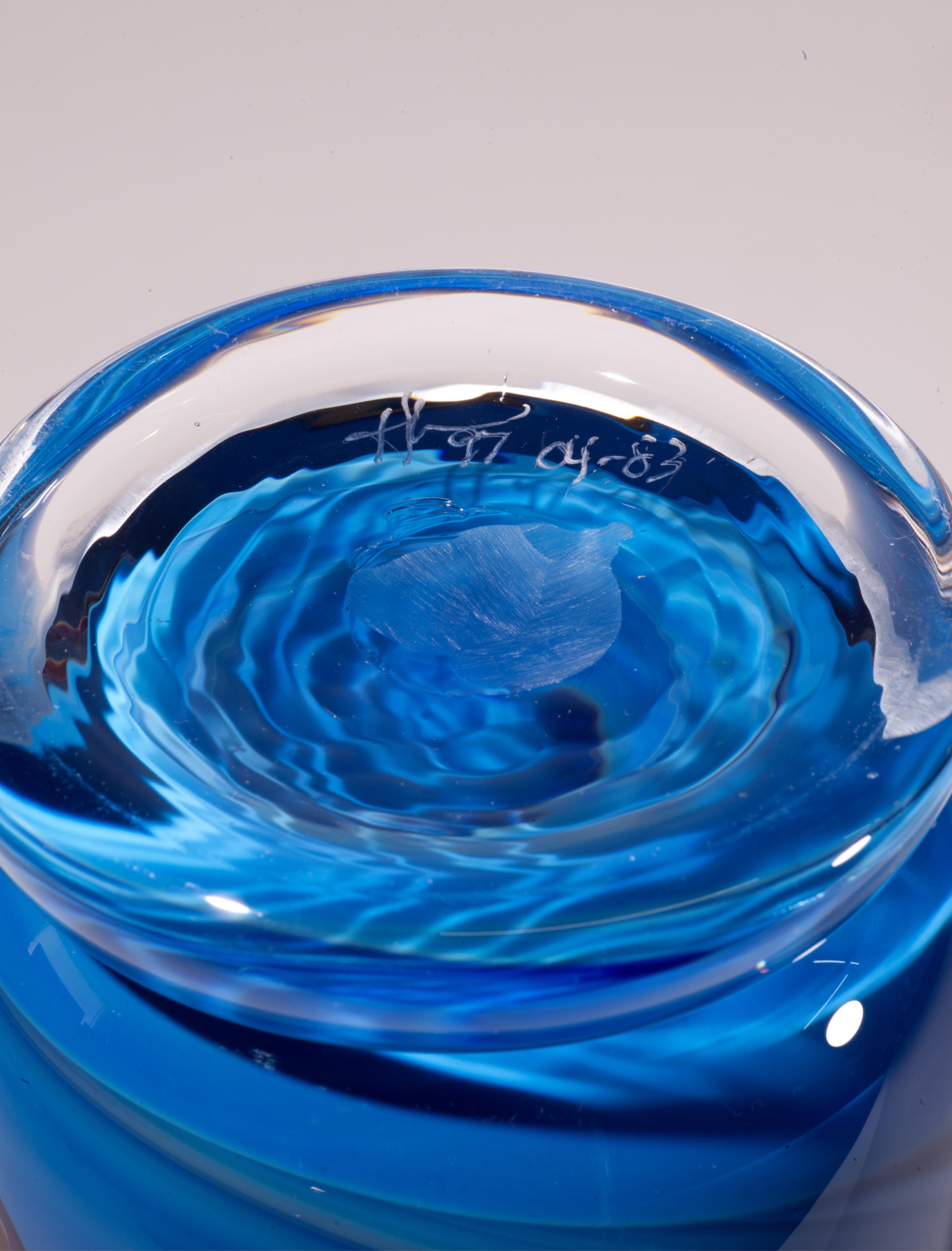  Graphic art glass vase was created with intertwining spiral coil helixes in dark red and pale-yellow glass fused in clear glass layer; the clear glass is encasing the deep, complex blue glass core in sommerso technique. The placement of helixes in