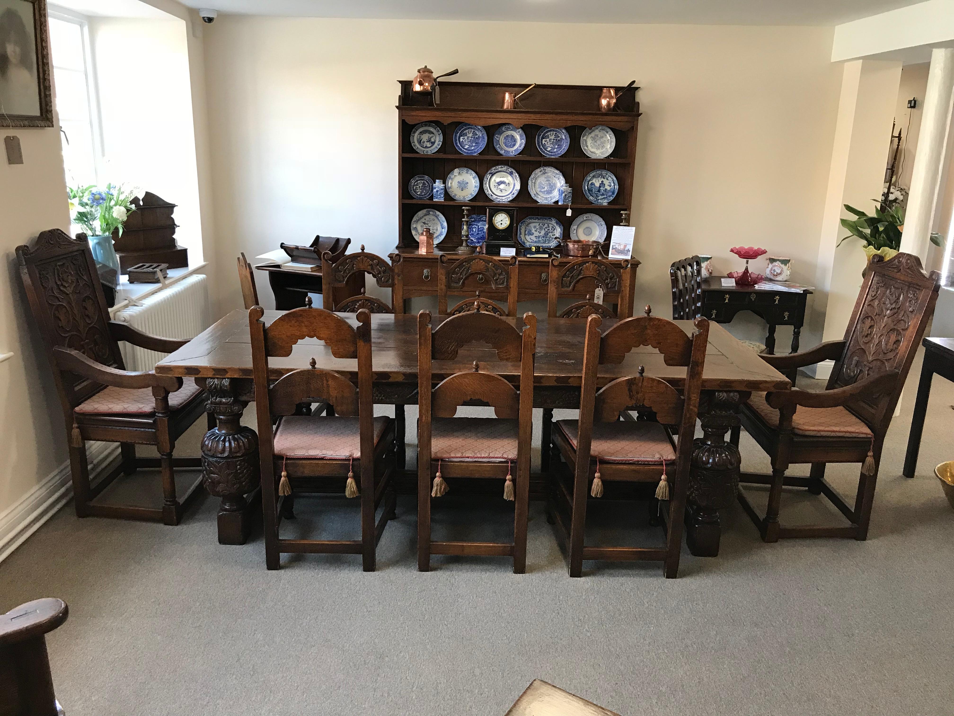 Superior quality handmade fully carved oak refectory table with carved cup and cover legs with beautiful walnut and sycamore inlay to the sides of the table top and strecher. Seats eight people comfortably, the pictured chairs are also currently
