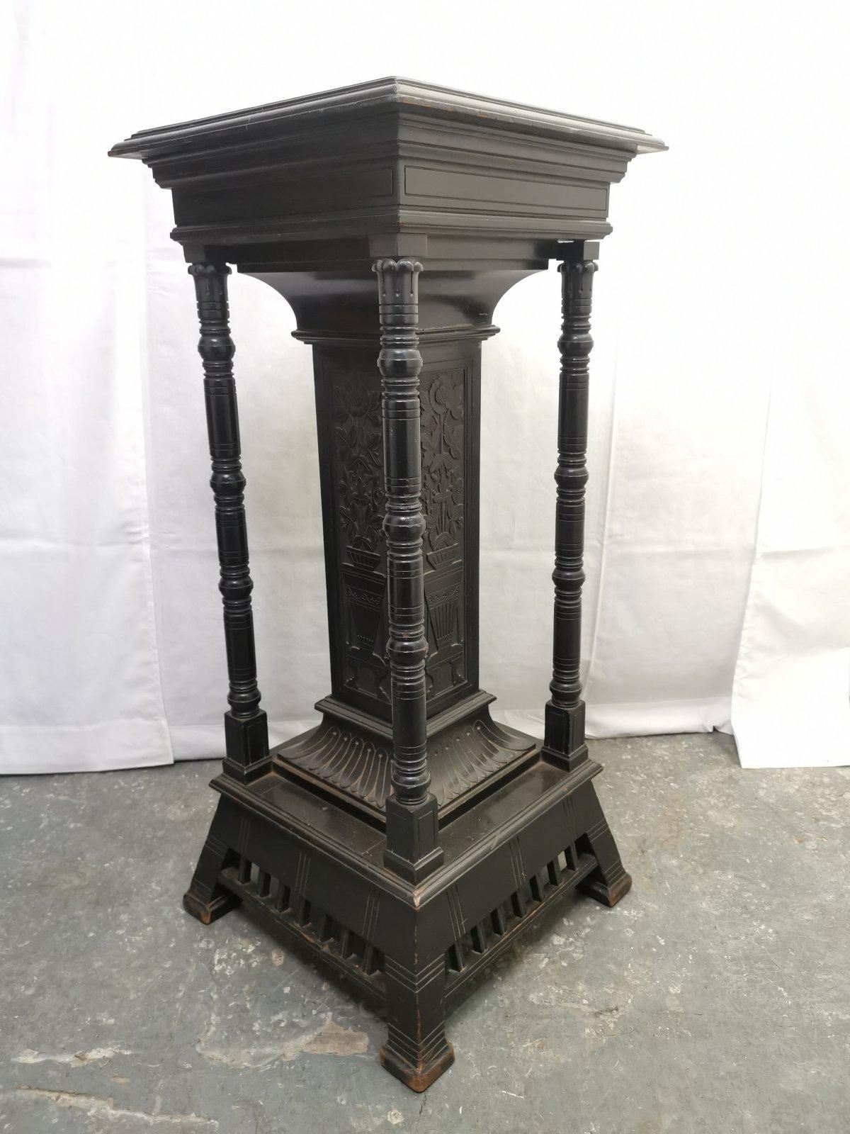 Henry W Batley attributed. Probably for Collinson and Lock.
An Aesthetic Movement ebonized pedestal base with a central pillar adorned on all four sides with carved sunflowers in a stylized planter and four turned upright supports, with carved Lotus