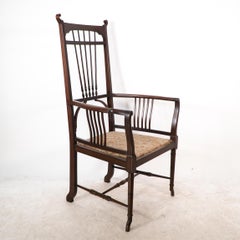 Henry W Batley attr. An Aesthetic Movement walnut armchair with sinuous touches.