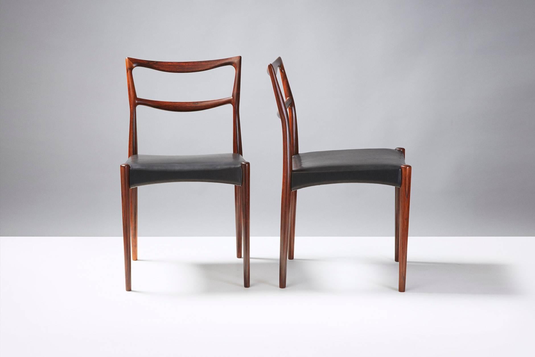 Rarely seen, sculptural dining chairs from Henry W. Klein. New black aniline leather seats. Stunning, exotic rosewood grain. Produced by Bramin, Denmark.

    