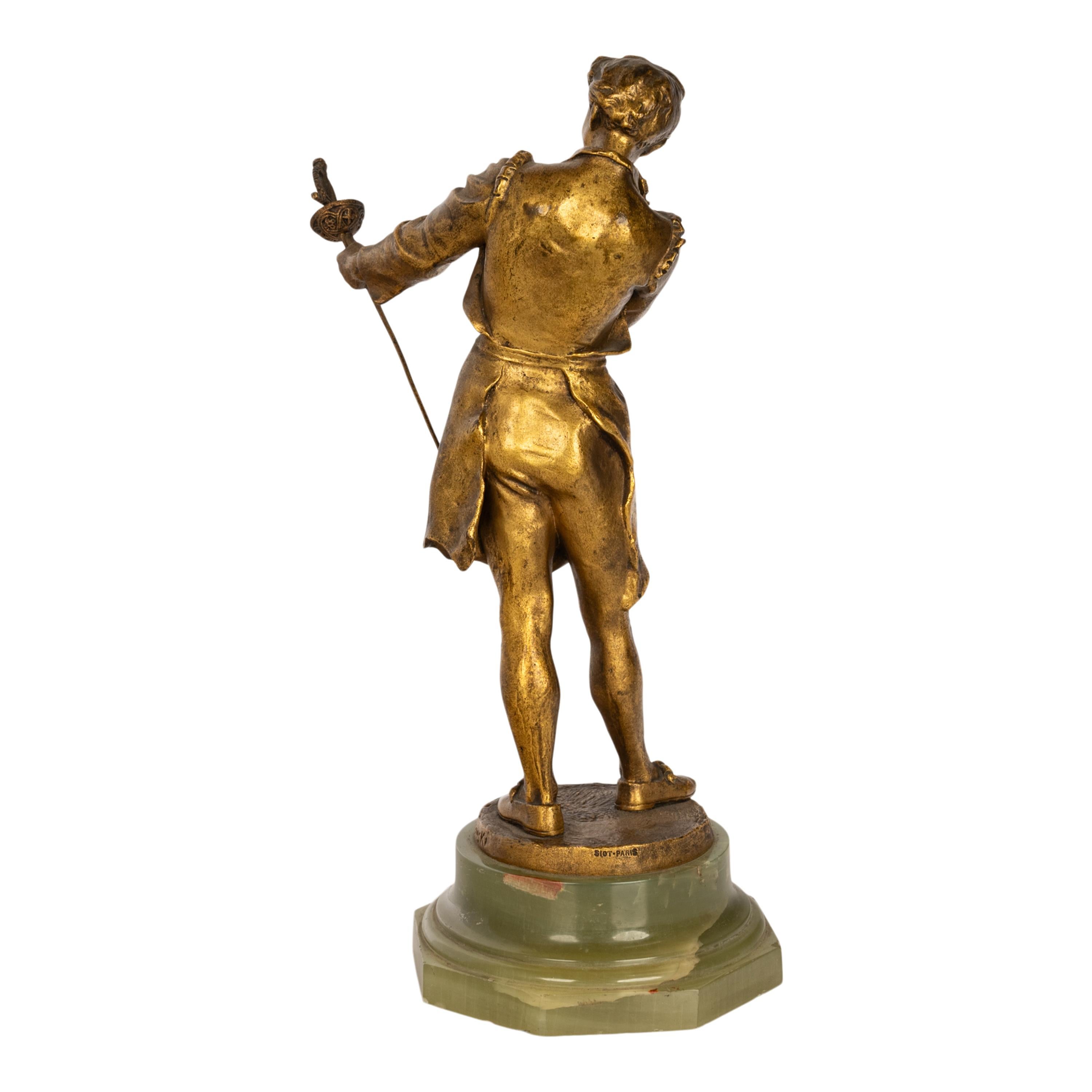 Fina escultura antigua francesa de bronce dorado de un espadachín, obra del artista y escultor franco-polaco Henryk II Kossowski (1855-1921), el bronce data de 1890.
El bronce representa a un forjador de espadas o cuchillas, vendiendo su espada y