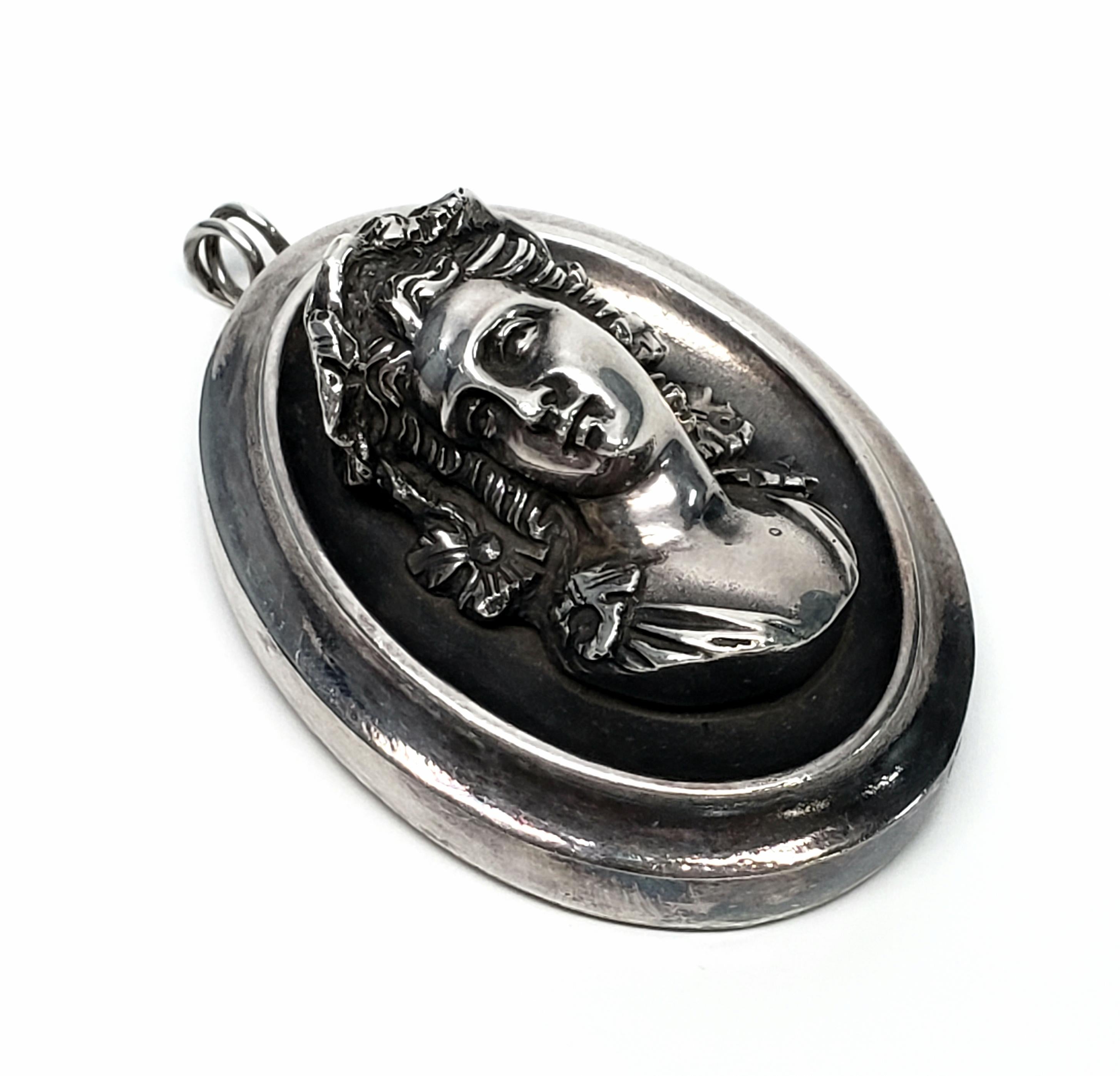Vintage sterling silver pendant by Henryk Winograd featuring a repousse cameo of a lady's head.

Henryk Winograd was a leader in America in the art of Repousse. He used sheets of fine silver and hand crafted sharp, high relief designs. His work is