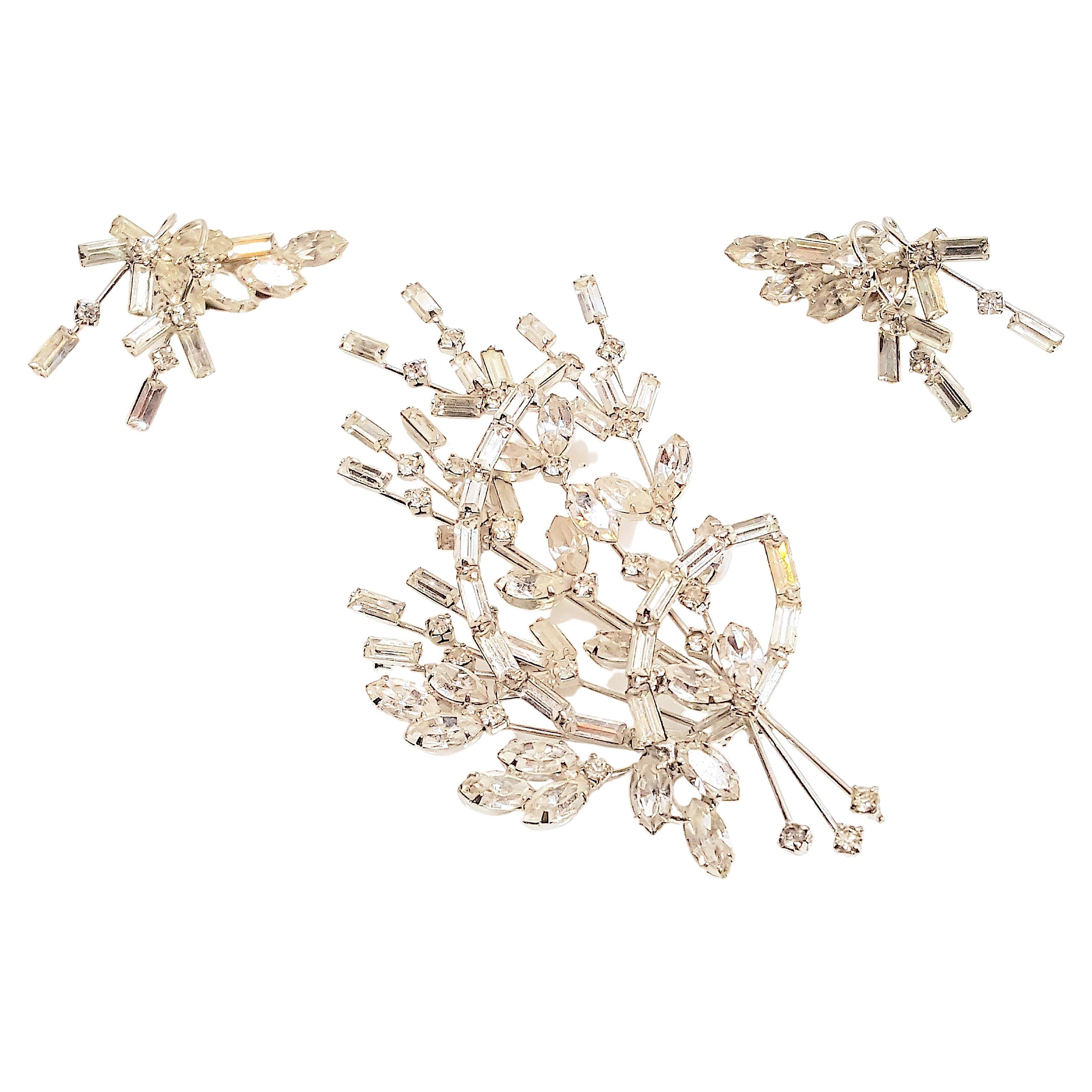 Henry Schreiner, the Austrian-born blacksmith founder of Schreiner in New York in 1932, handcrafted this demi-parure of prong-set colorless crystal stylized-foliage sprays after he began designing extravagant silver-soldered settings around the