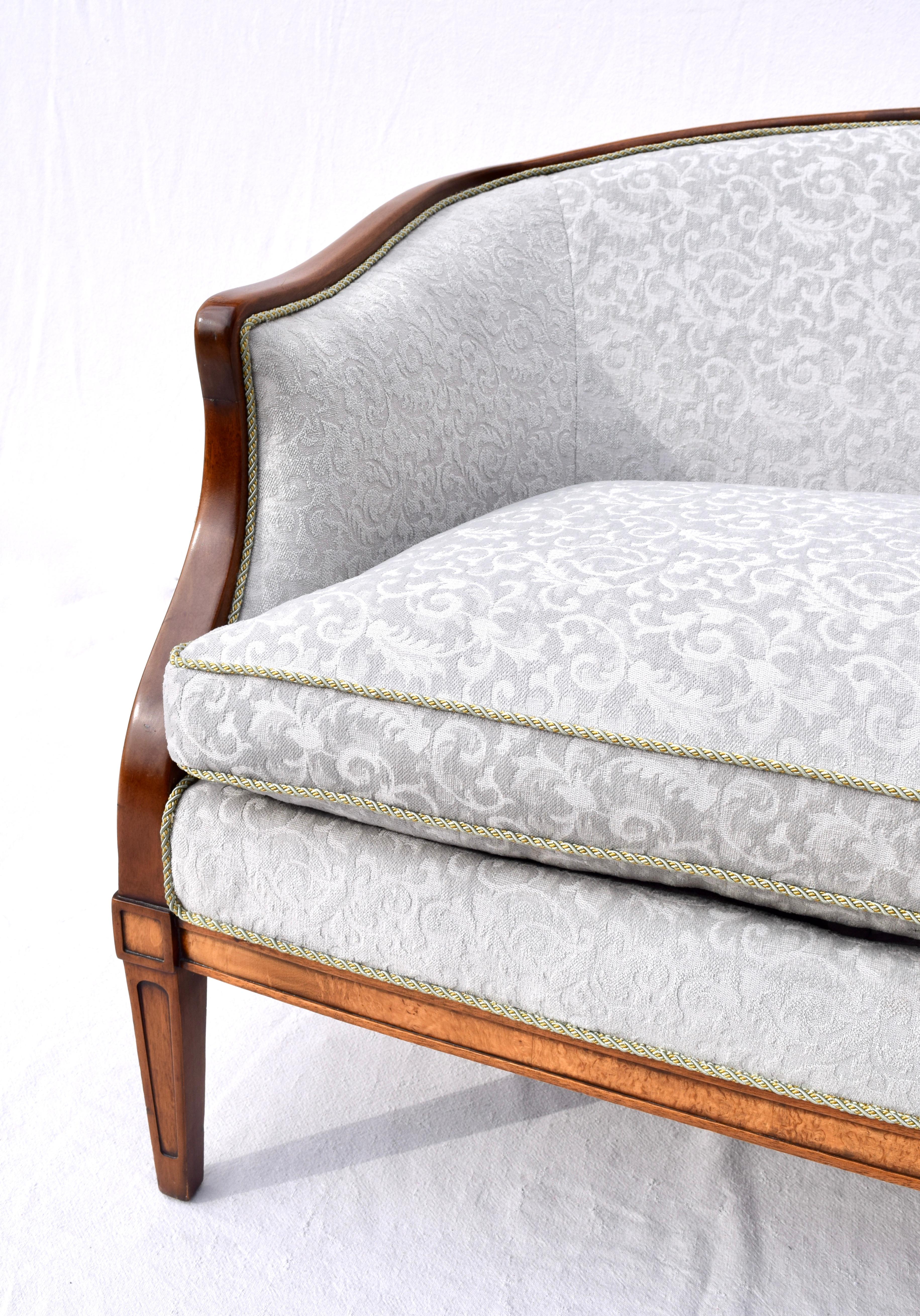 Vintage Hepplewhite style mahogany settee with tapered and burl inlay legs. Exceptional custom upholstery in soft grey cut velvet with single plush goose down cushion. Graceful lines in the arched back, rolled mahogany arms and shaped rear legs.