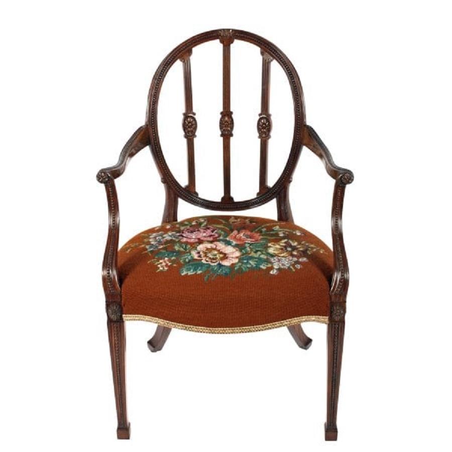 A fine example of an Edwardian mahogany Hepplewhite design arm or elbow chair.

The chair has an oval back that is inset with 'Pea' carving, three upright spats that are fluted and have oval carved patera.

The swept arms also have 'Pea' carving