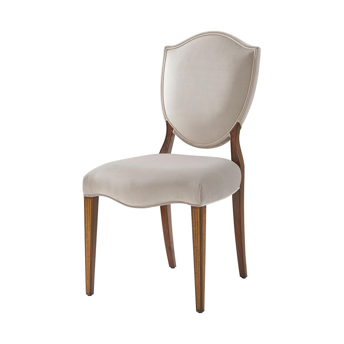 Two George III Hepplewhite style shield back side chairs, with an upholstered back with flame mahogany Veneered Back Supports, the upholstered seat on square tapering legs with satinwood faux fluted inlay.
Dimensions: 19