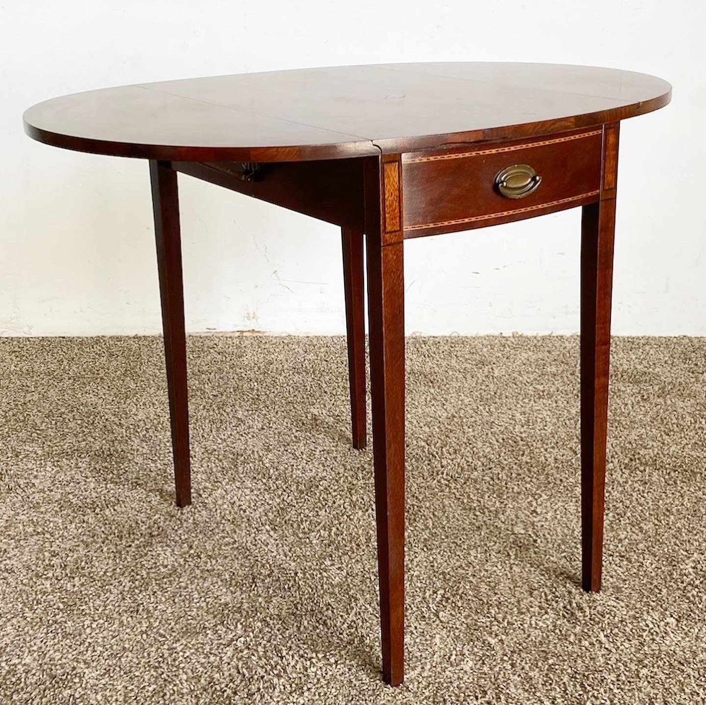 Enhance your space with the exceptional vintage Hepplewhite drop leaf table by Mersman. This table features an ornate urn-shaped design and two drop leaf sides, combining elegance and functionality. Closes to 17.5”W

Exceptional vintage Hepplewhite