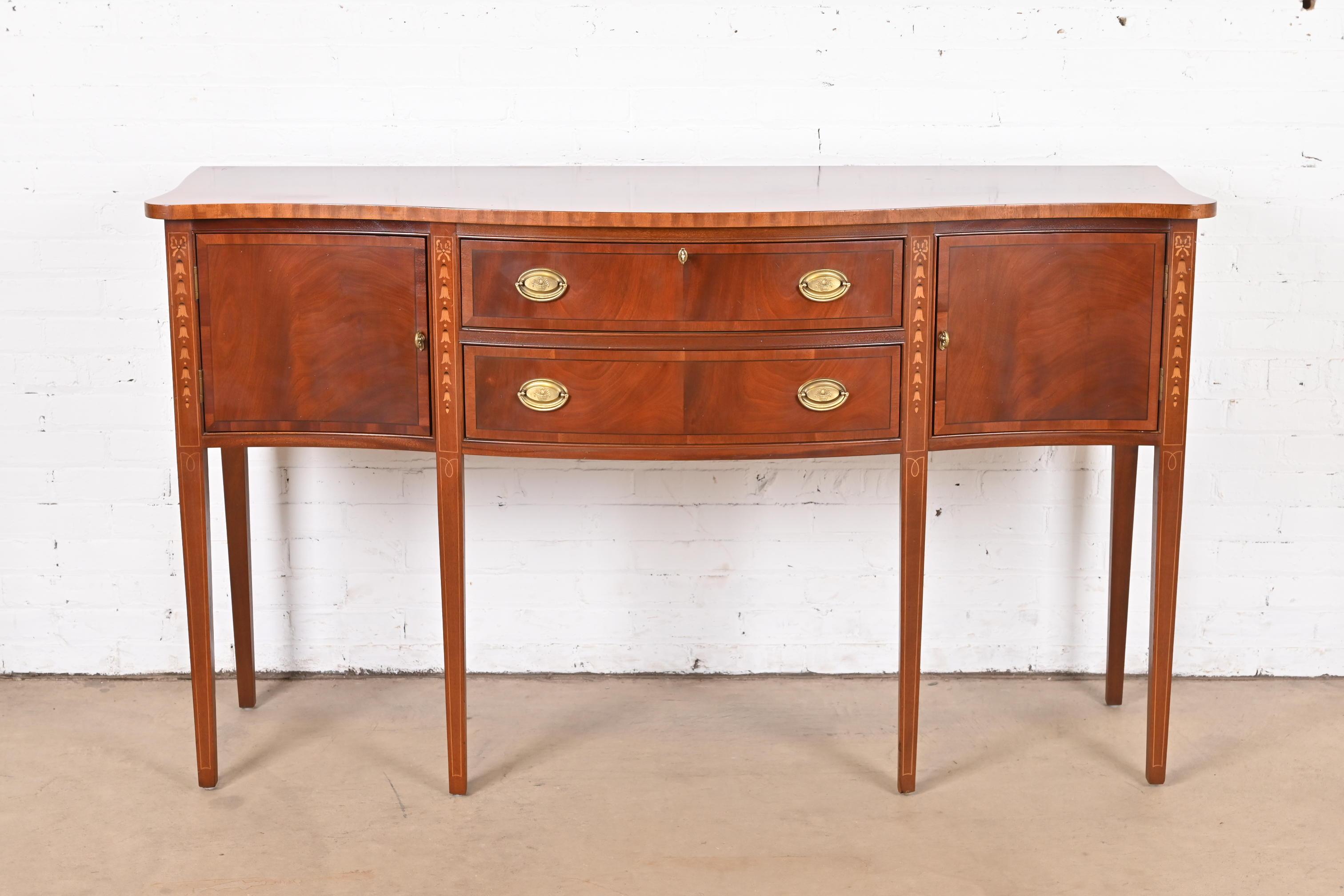 A gorgeous Hepplewhite or Federal style serpentine front sideboard, buffet, or credenza

USA, Late 20th Century

Flame mahogany, with inlaid satinwood marquetry and banding, and original brass hardware.

Measures: 65.5
