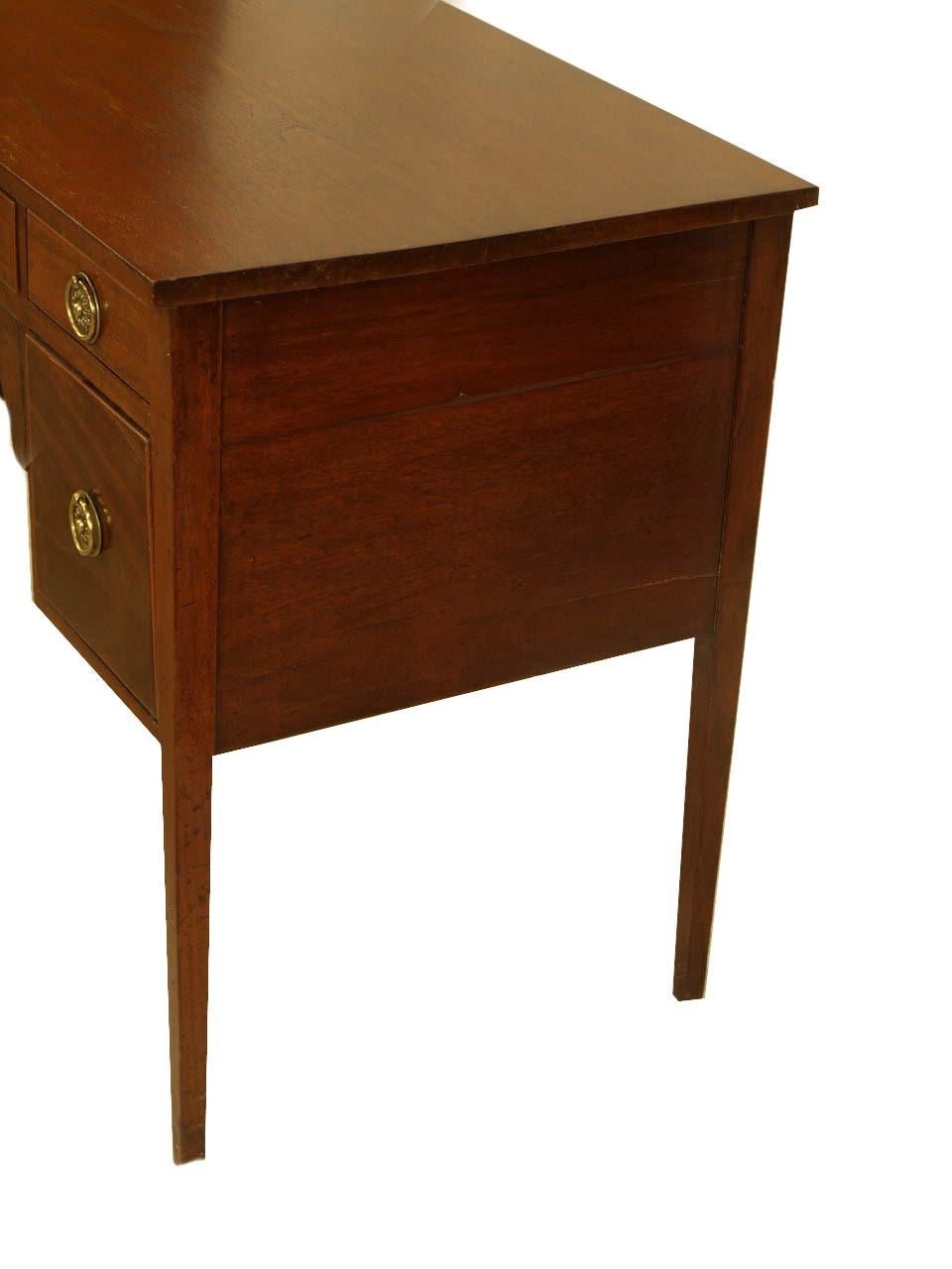 Hepplewhite mahogany server, the five drawers with round ring pulls are flanking the center with a nicely arched apron, the drawers are banded around the edges with boxwood. This petite server with tapered legs has a very nice patina and color.