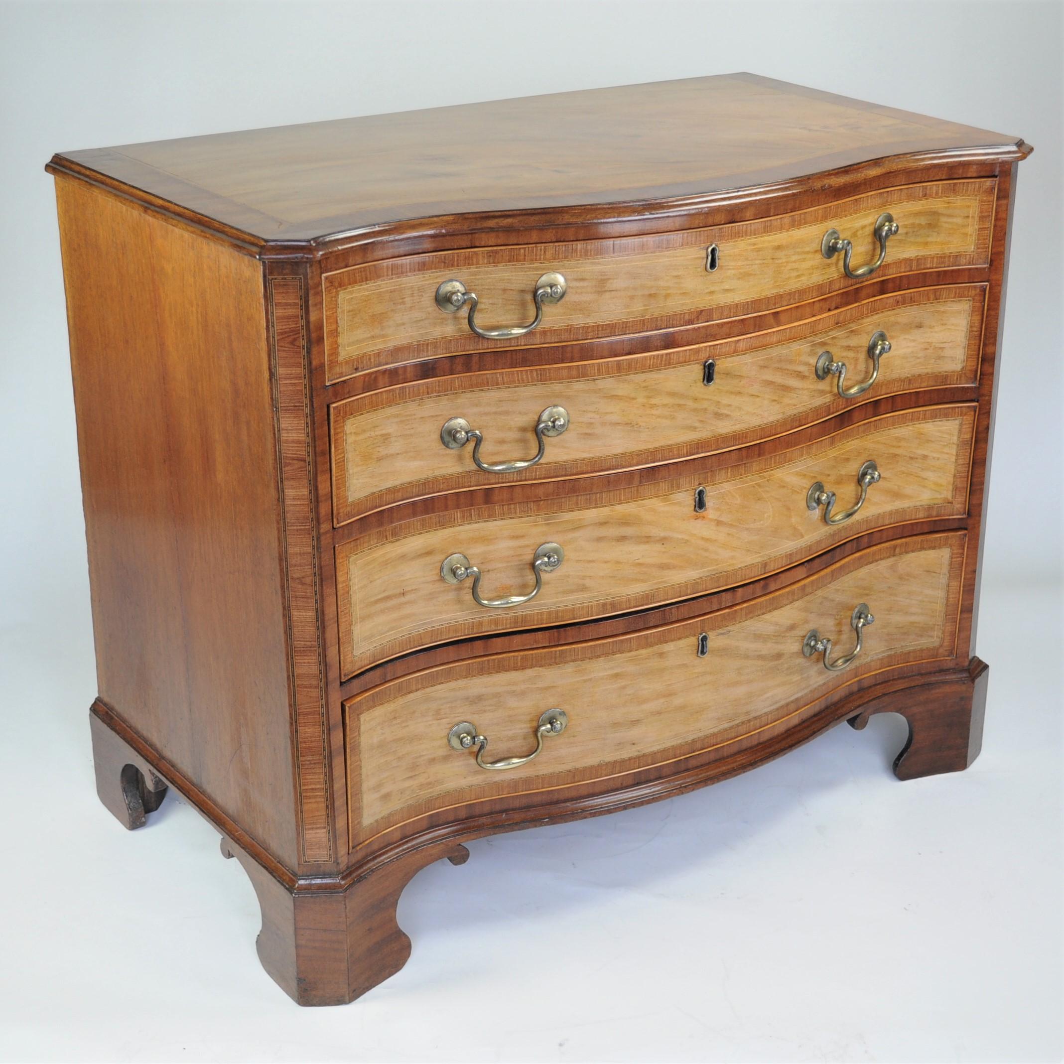 Eine hervorragende Kommode mit vier langen Schubladen aus gemasertem Satinholz, Tulipwood-Einlagen und Mahagoni. Das Oberteil mit Linien- und Schachbrettlinieneinlagen und breiten Tulpenholzbändern, darüber die vier langen Schubladen mit passendem