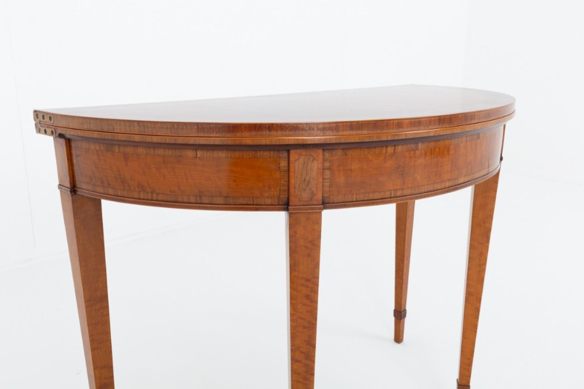 Hepplewhite Stil Satinholz Kartentisch
Dieser Kartentisch steht auf konisch zulaufenden Beinen mit Fußschlaufen aus Palisanderholz
CIRCA 1900
Die Platte des Tisches hat eine segmentierte Form mit Palisander-Kreuzstreifen und geformten