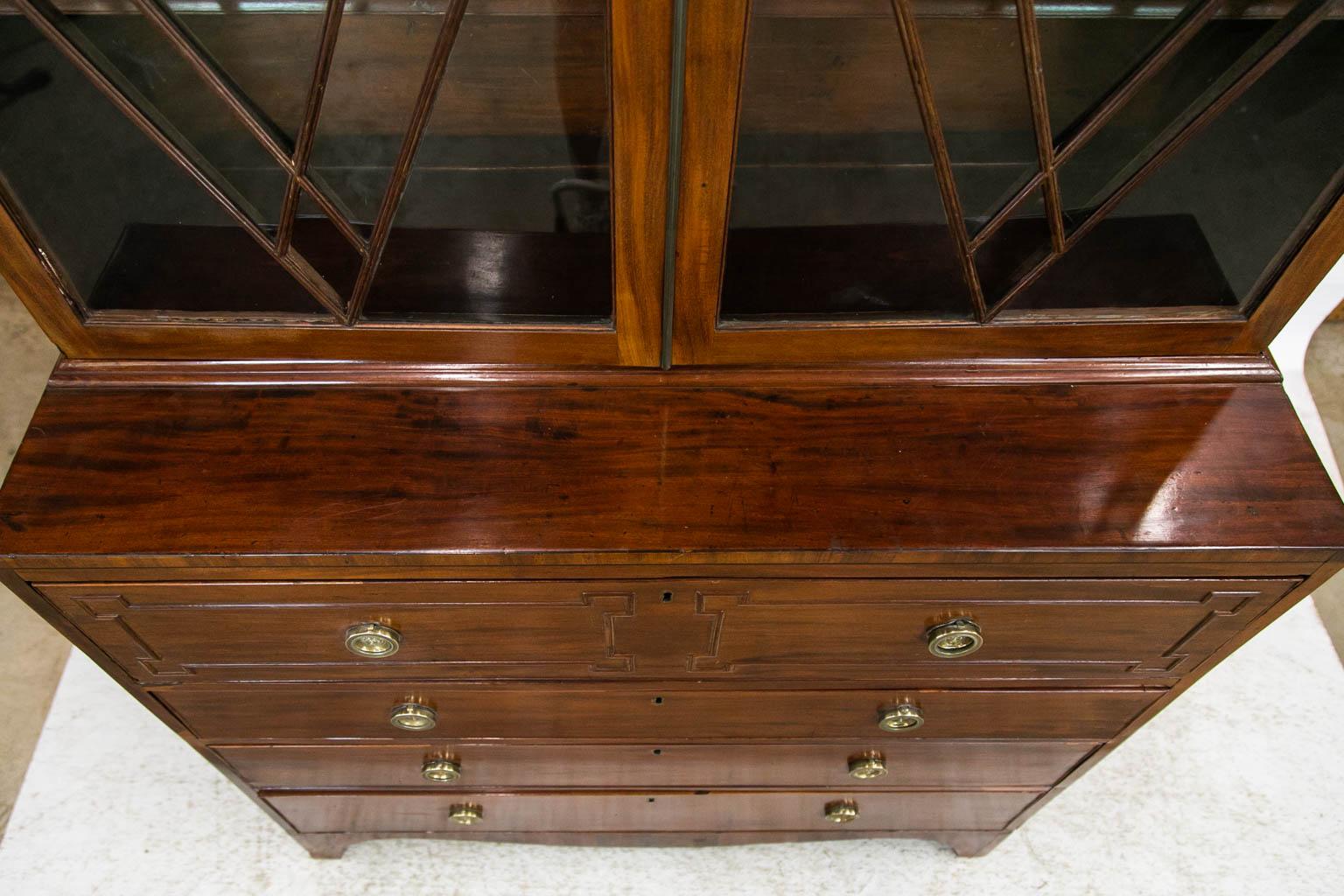 This English mahogany secretaire has its original wavy glass. The interior has ten drawers and six cubby holes. The brasses are later.