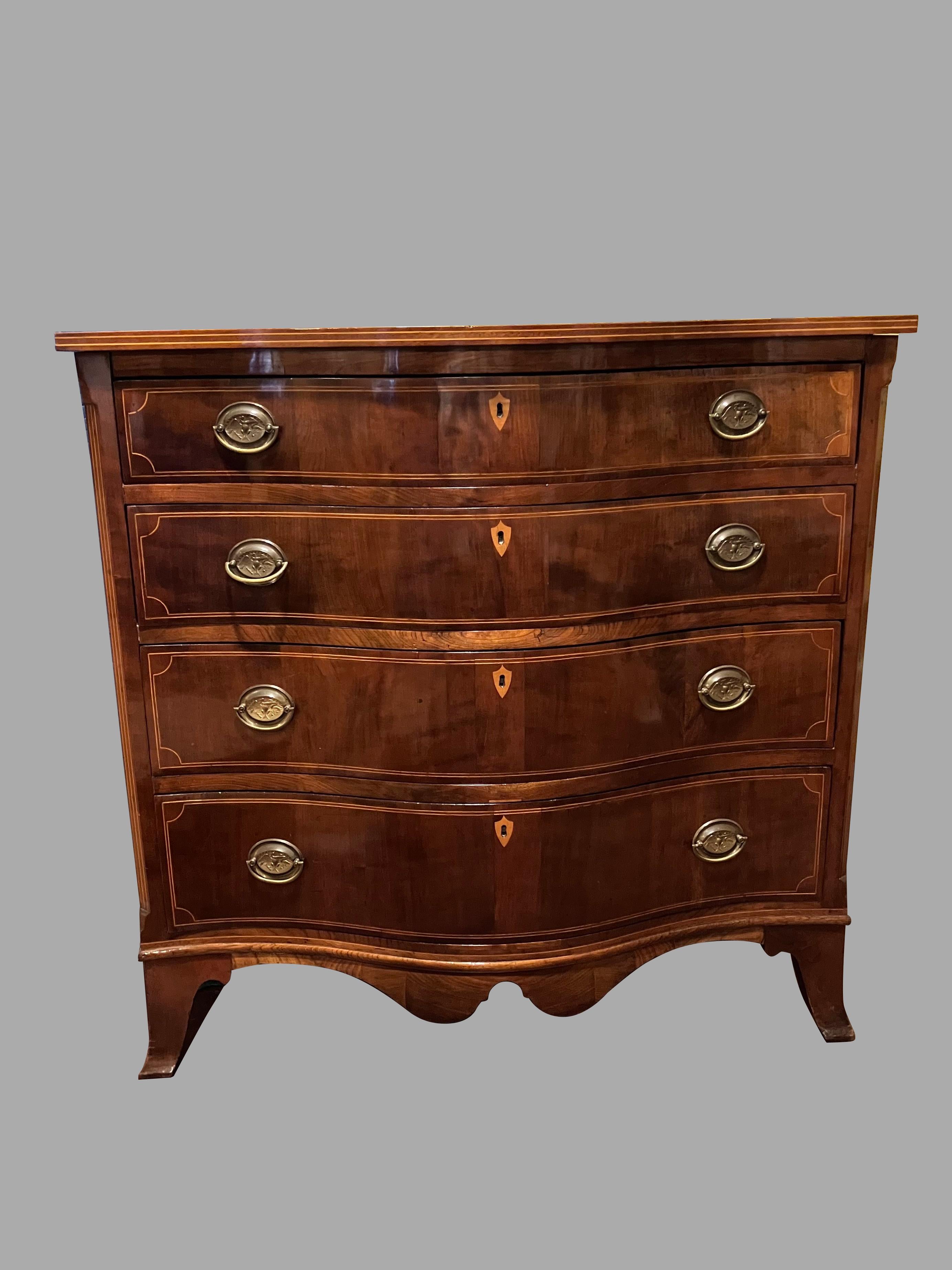 A good quality American Hepplewhite style inlaid mahogany chest of drawers of serpentine form, the well-figured top with a boxwood inlaid edge above 4 graduated drawers each with line inlay and contrasting keyhole escutcheon all resting on French