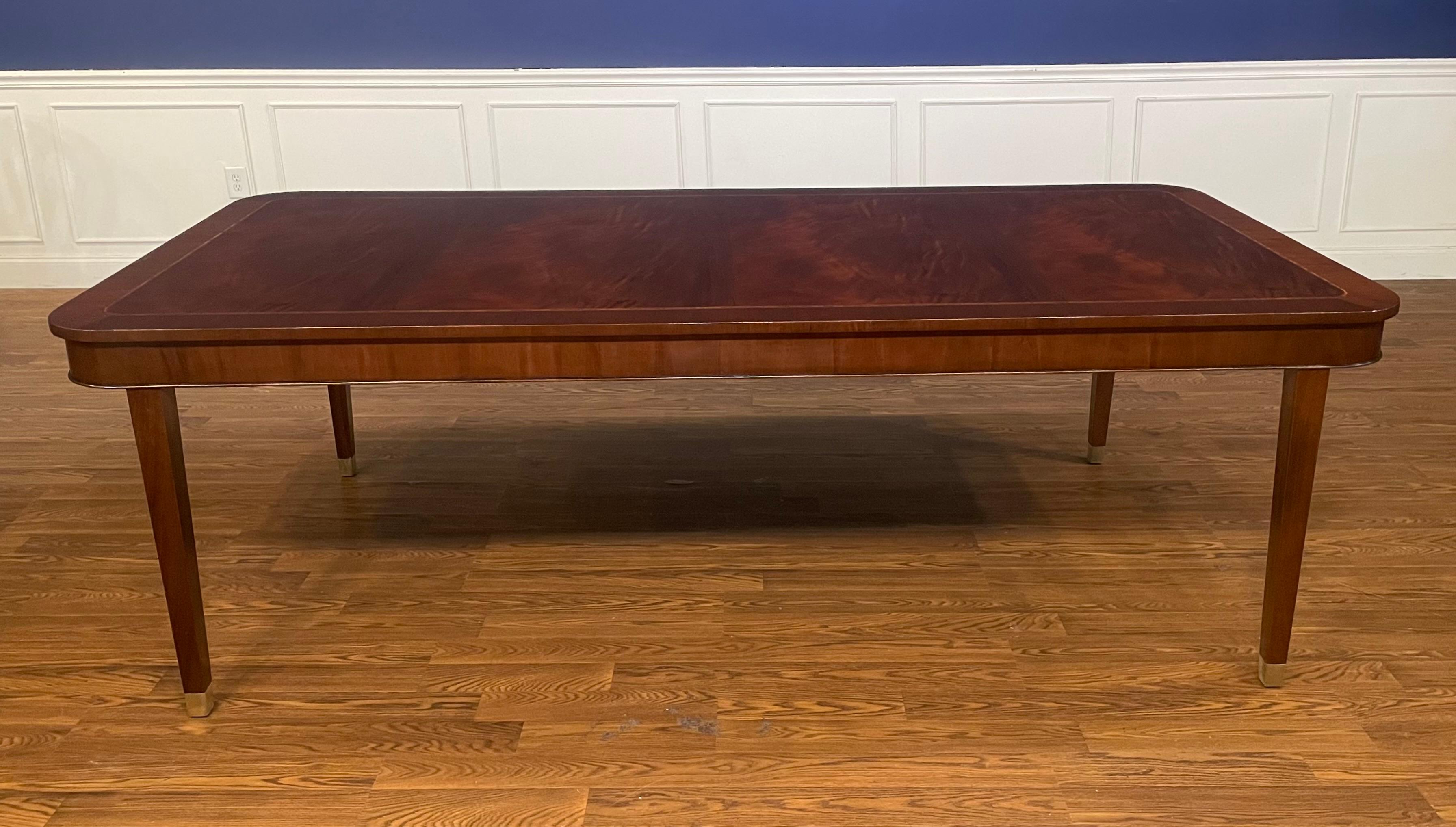 This table is made-to-order in the Leighton Hall shop in Suwanee, Georgia. It features classic Hepplewhite styling with a swirly crotch mahogany field, straight grain mahogany border and classic Hepplewhite style square tapered legs. The legs