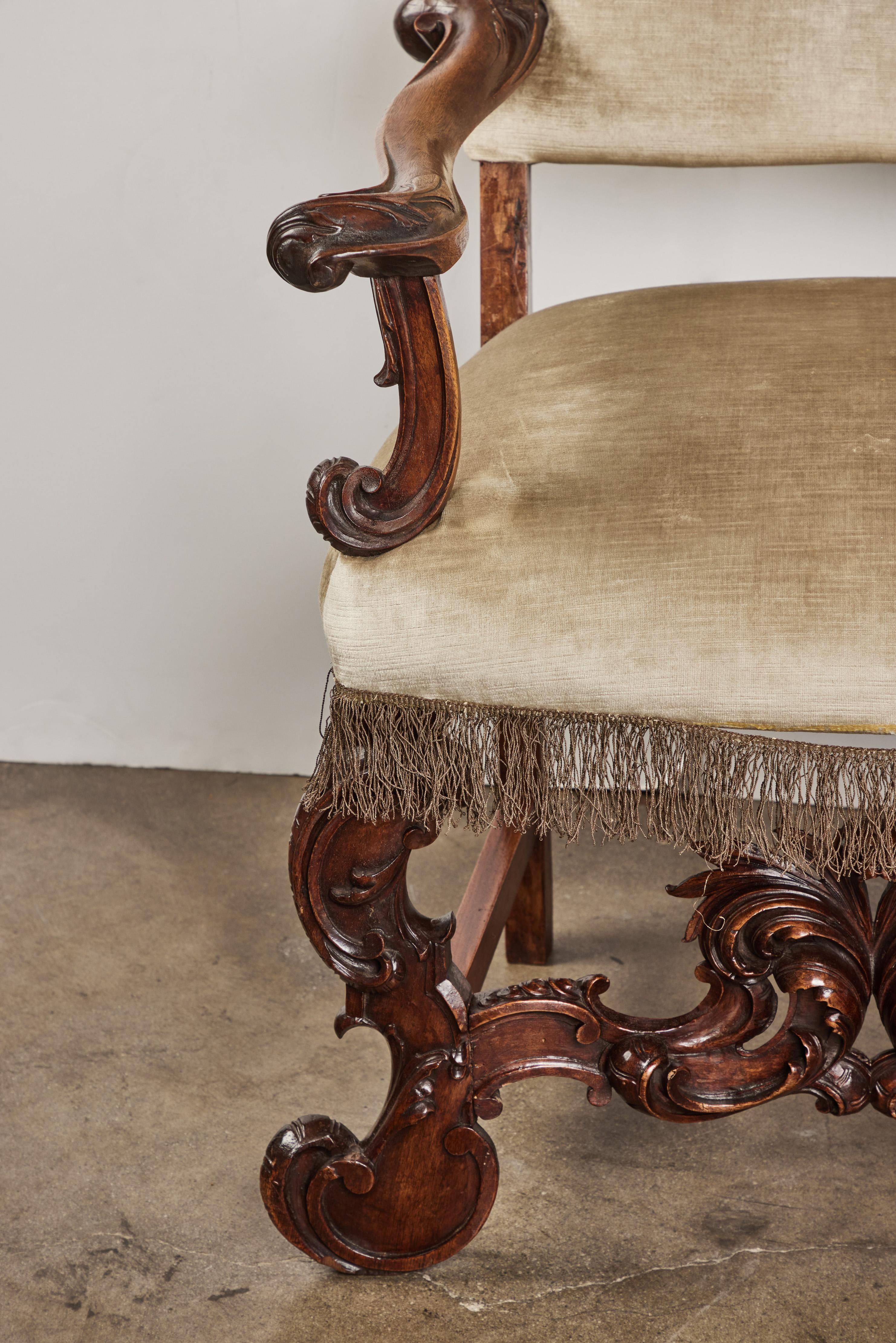 Ein reich geschnitzter venezianischer Armlehnstuhl aus Nussbaum.  Bezogen mit späterem Samt mit antiken Fransen.  Dies ist der 