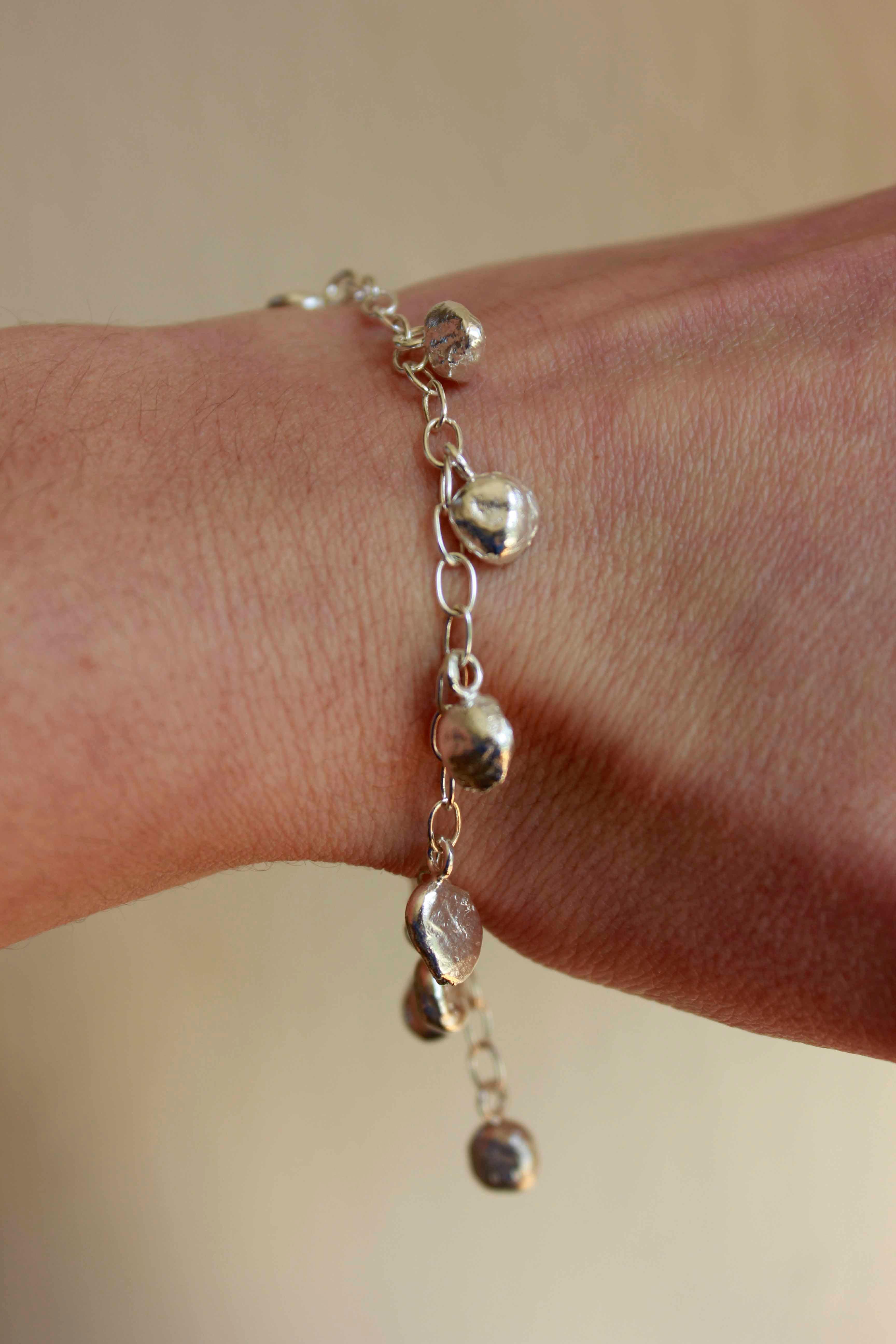 Le bracelet Hera se compose de 11 boules en argent suspendues à une chaîne en argent.

Le bracelet est réglable et sa longueur maximale est de 21 cm.

Les petites boules organiques sont fabriquées à partir de nos déchets d'argent, ce qui signifie
