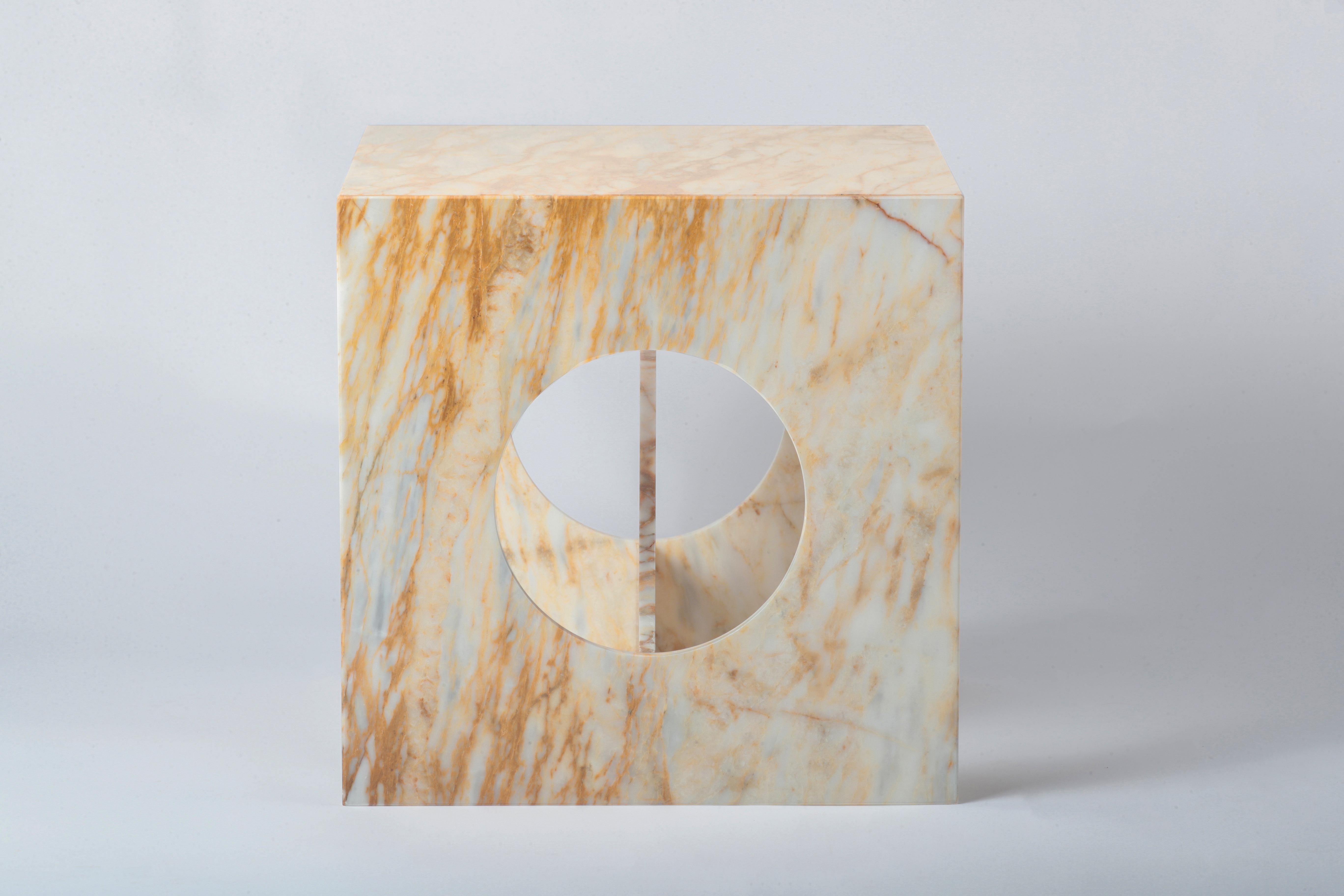 A study in geometric harmony and material richness, Hera Table merges architectural precision with sculptural fluidity. Its cube-like structure, punctuated by circular cutouts, creates a dynamic interplay of solid and negative space, enhancing both