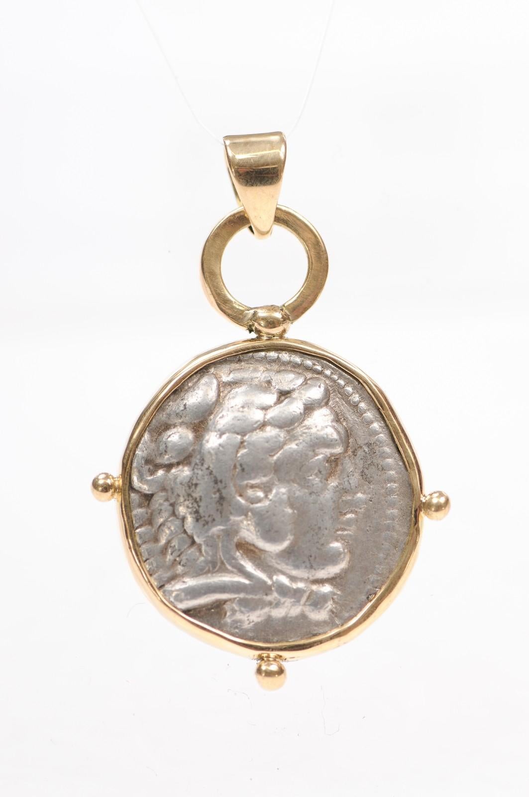 A Silver Tetradrachm [coin] displaying the head of Heracles and Zeus enthroned. This marvelous coin is from the Kingdom of Macedonia of Classical Greece, and was minted at Ake or Tyre circa 317 BC. There is delicate 18 karat gold trim around the