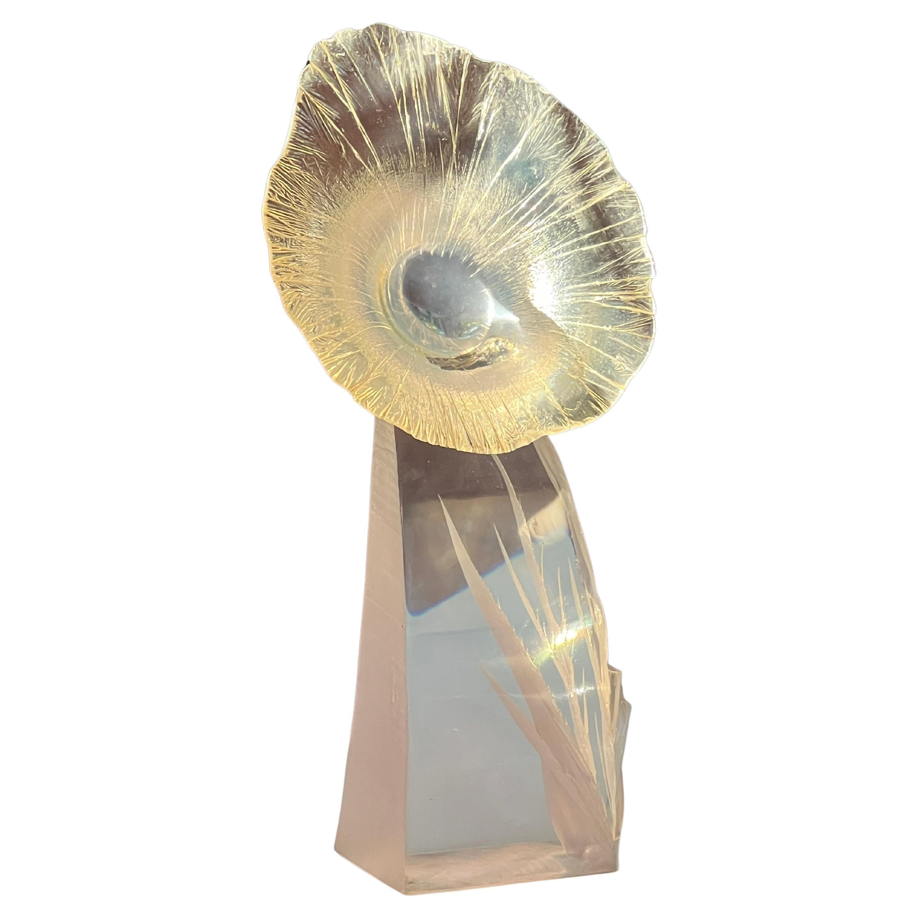 This rare Lucite resin sculpture, bearing the signature of Herb Elsky and dated 1983 on its base, portrays a flower and its stem intricately carved within two acrylic blocks joined together.  It could be a phantasmal sunflower in the color of