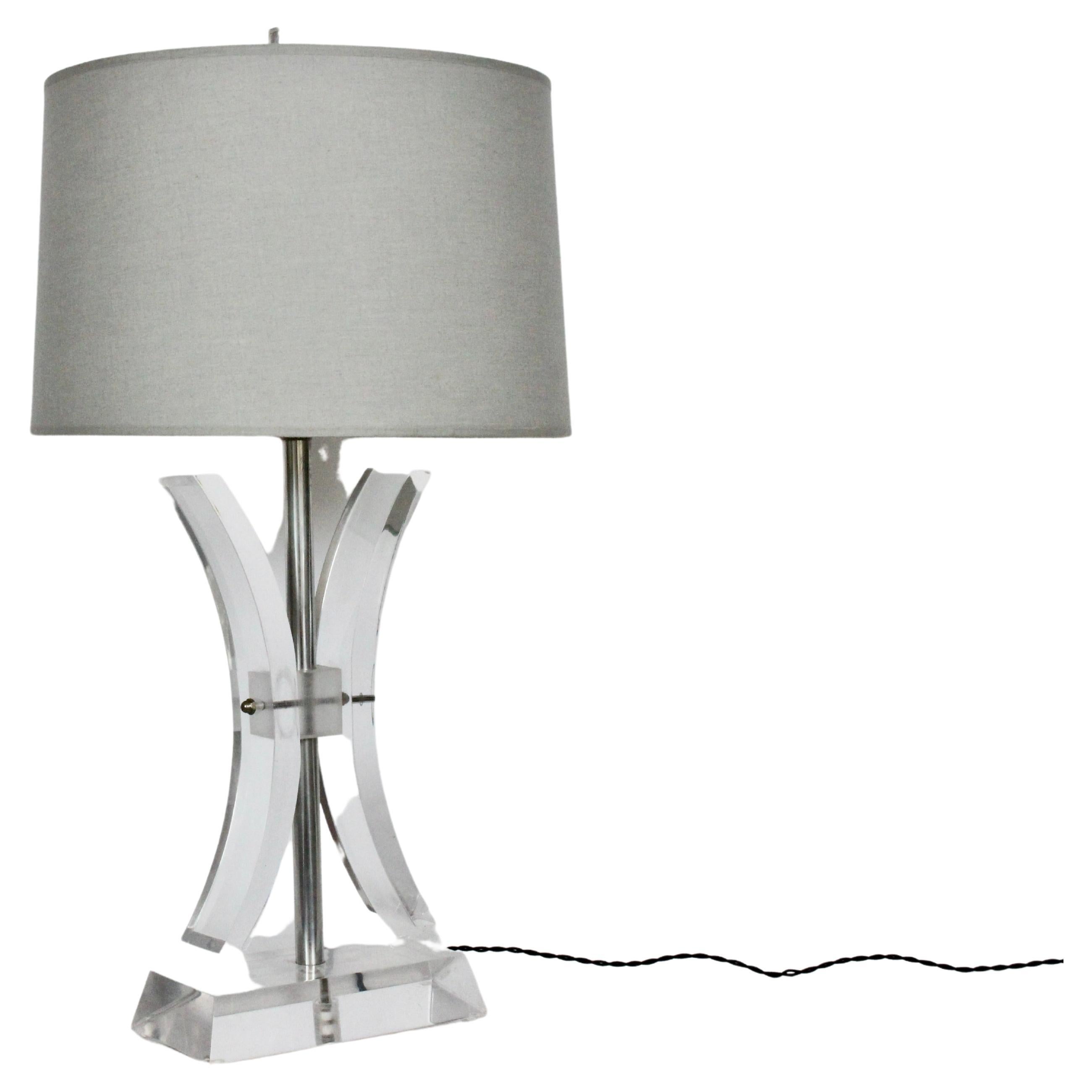 Herb Ritts attributed for Astrolite transparent Lucite & Chrome Two Fin table lamp. Featuring a Modernist hourglass form with central Chrome stem and central joint securing two curved, flared Acrylic swags, atop a (5D x 10W x 2H) angled rectangular