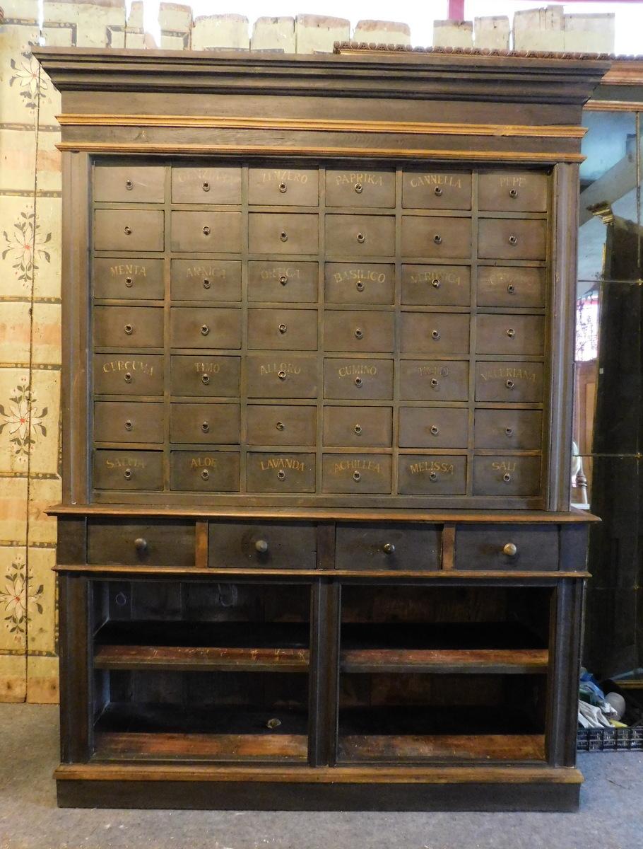Antiguo contenedor de credenzas, cómoda de farmacia/herbolario con cajones de varios tamaños y estantes, lacada y pintada con nombres de las especies de hierbas en los cajones, encantadora en una cocina o en el bar de un restaurante de