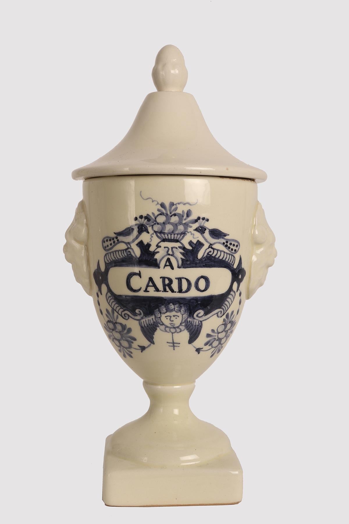 Large white ceramic apothecary-herbalist jar with cobalt blue decorations, to contain Thistle in a neoclassical style. The handle of the lid is in the shape of an acorn, on the sides of the vase there are two decorative elements in the shape of lion
