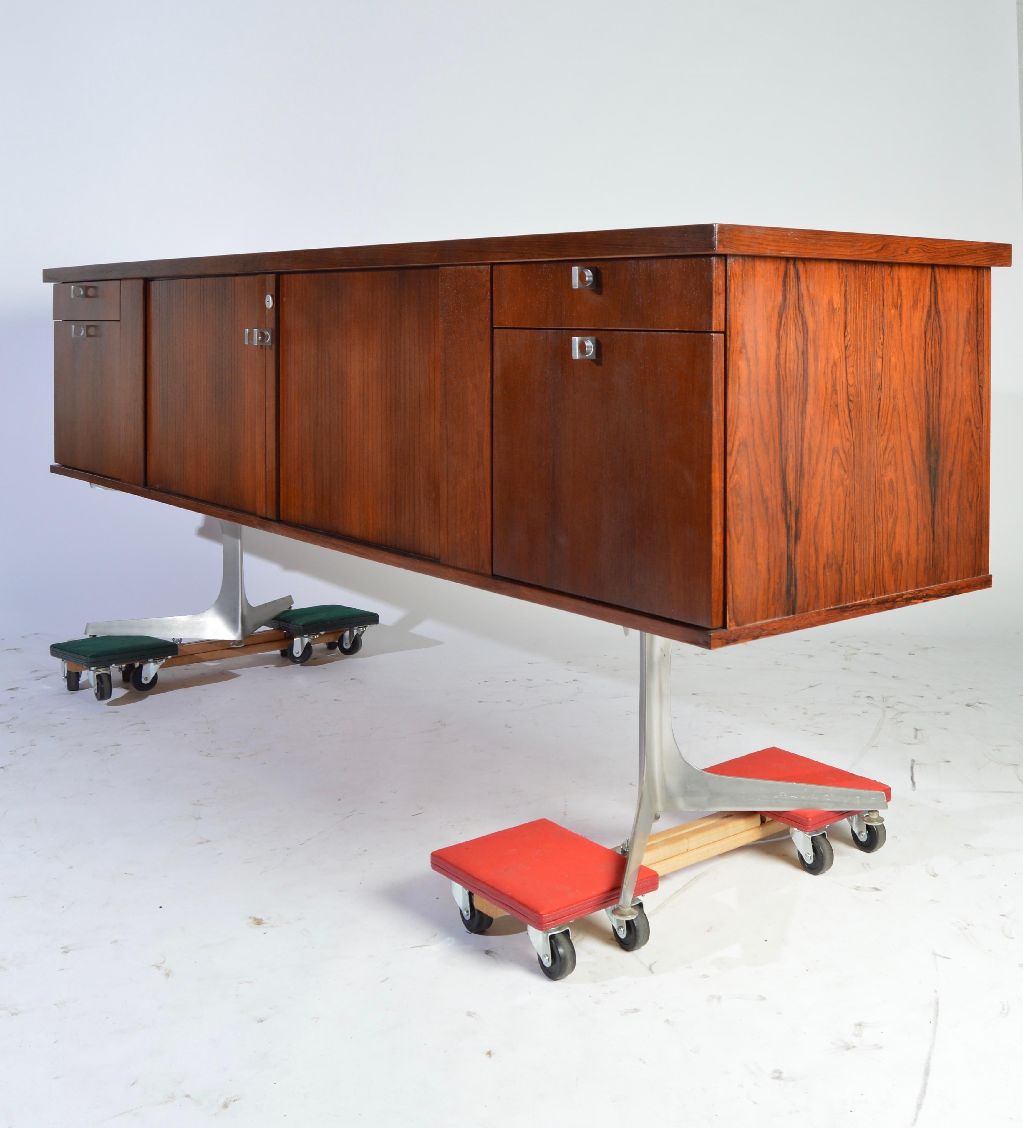 Herbert Hirche Minimalist ‘Top Series’ Rosewood Credenza having Tambour center doors that reveal ample case storage to the left and a wine or liquor rack to the right, which pulls out should you not need it.
The left and right sides of the case