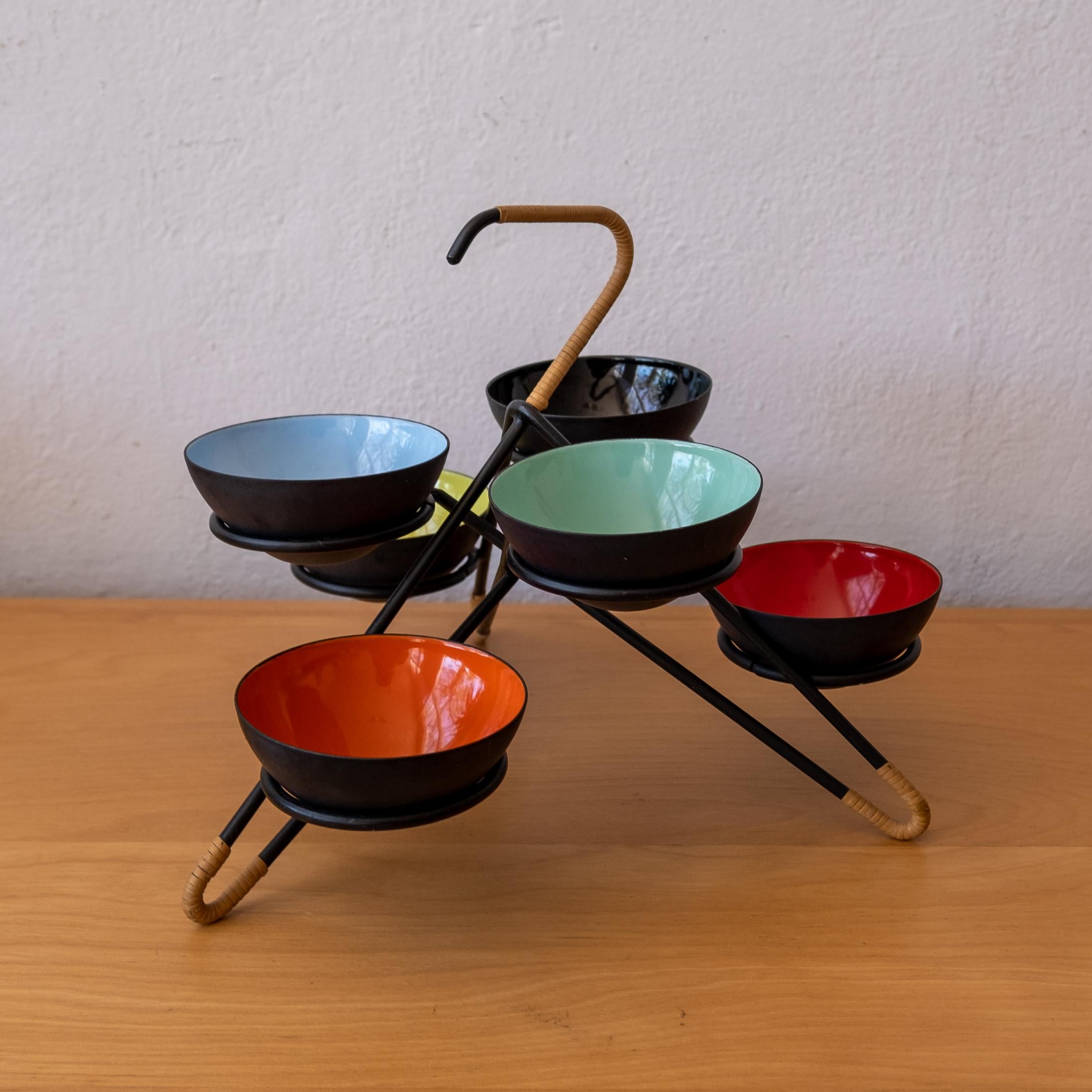 Extremely rare krenit set with stand and six enamel bowls. Designed by Herbert Krenchel. Metal stand with wrapped cane. 1950s, Denmark.