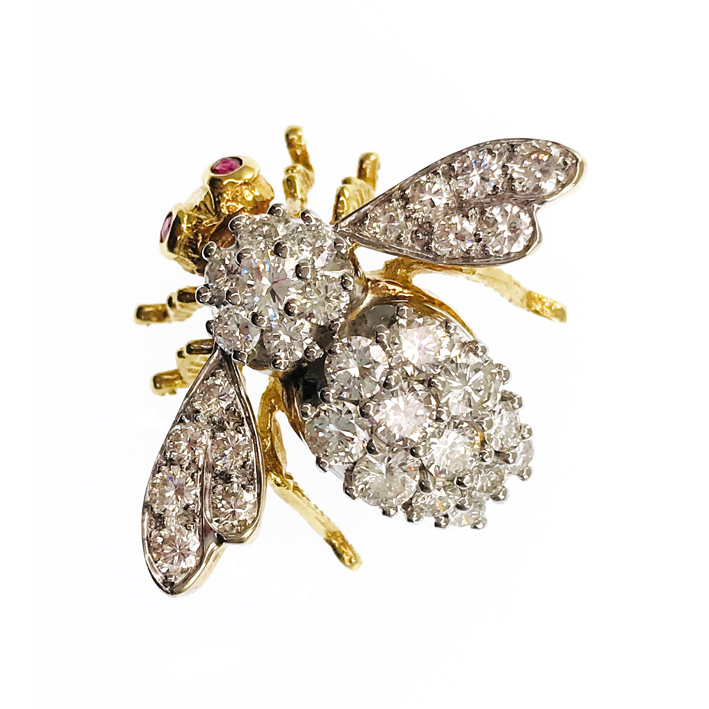 18 Karat Two-Tone Diamond Ruby Bee Brooch Pin. Thirty-one round graduate prong and pavé set diamonds gracefully adorn the body and outspread wings. Diamonds are VS1-VS2 (G.I.A.) in clarity and G-H (G.I.A.) in color with a weight of 3.26ctw. Two