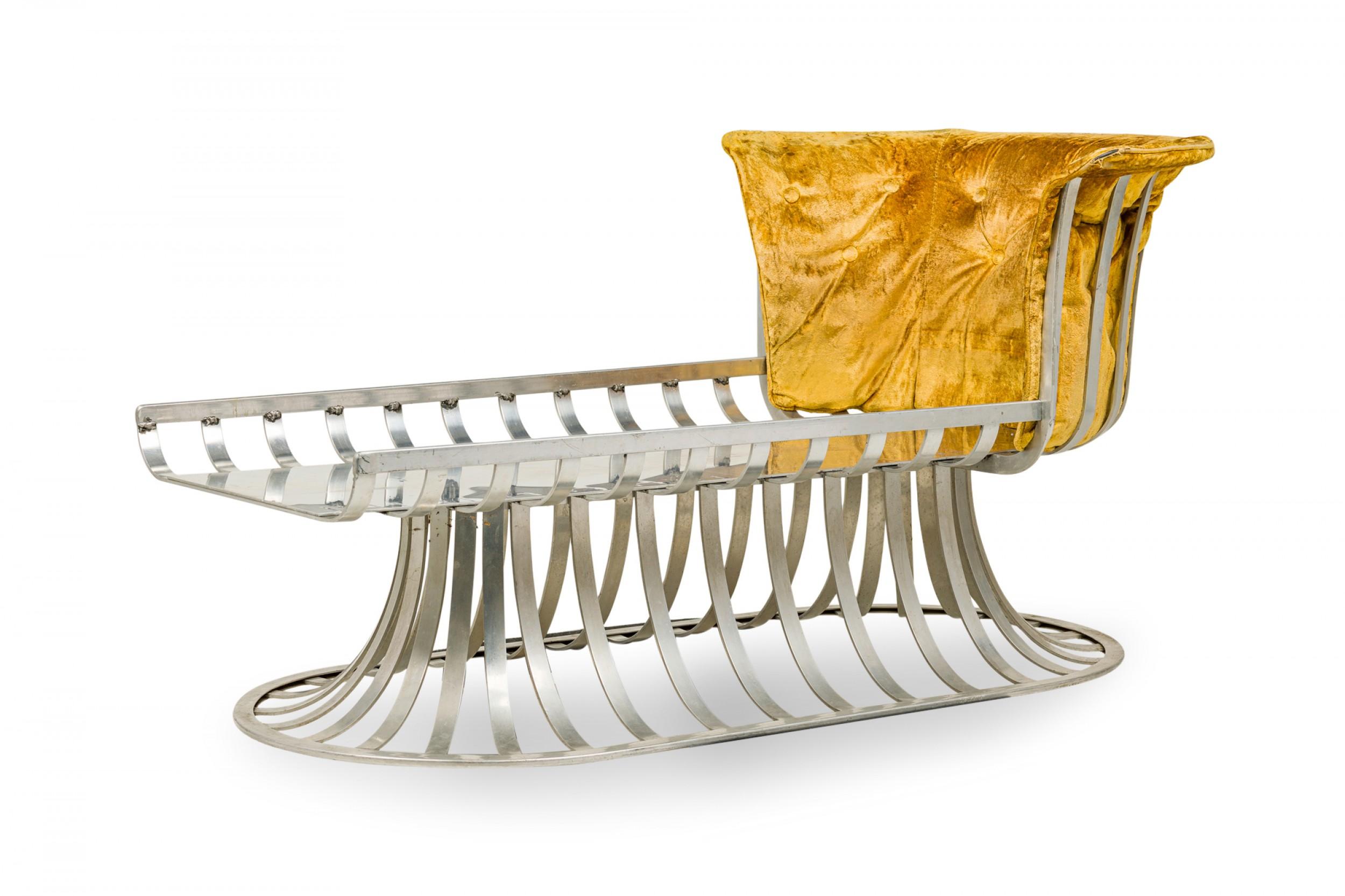 American Mid-Century chaise lounge with a form comprised of molded aluminum slats with a curved backrest on one side and a tulip base, with a button tufted crushed gold velvet upholstered seat and back cushion. (HERBERT SAIGER FOR LEE L. WOODARD &