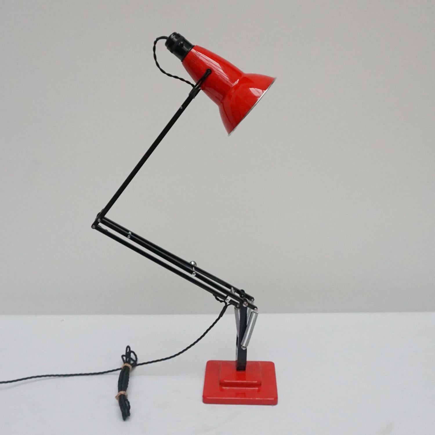 'Three-spring' 1930's prototype Anglepoise desk lamp by Herbert Terry & Sons. Black arm assembly with matching red two step base and perforated lamp shade. Original stamps to stem. The three spring Anglepoise lamp was first released by Herbert Terry