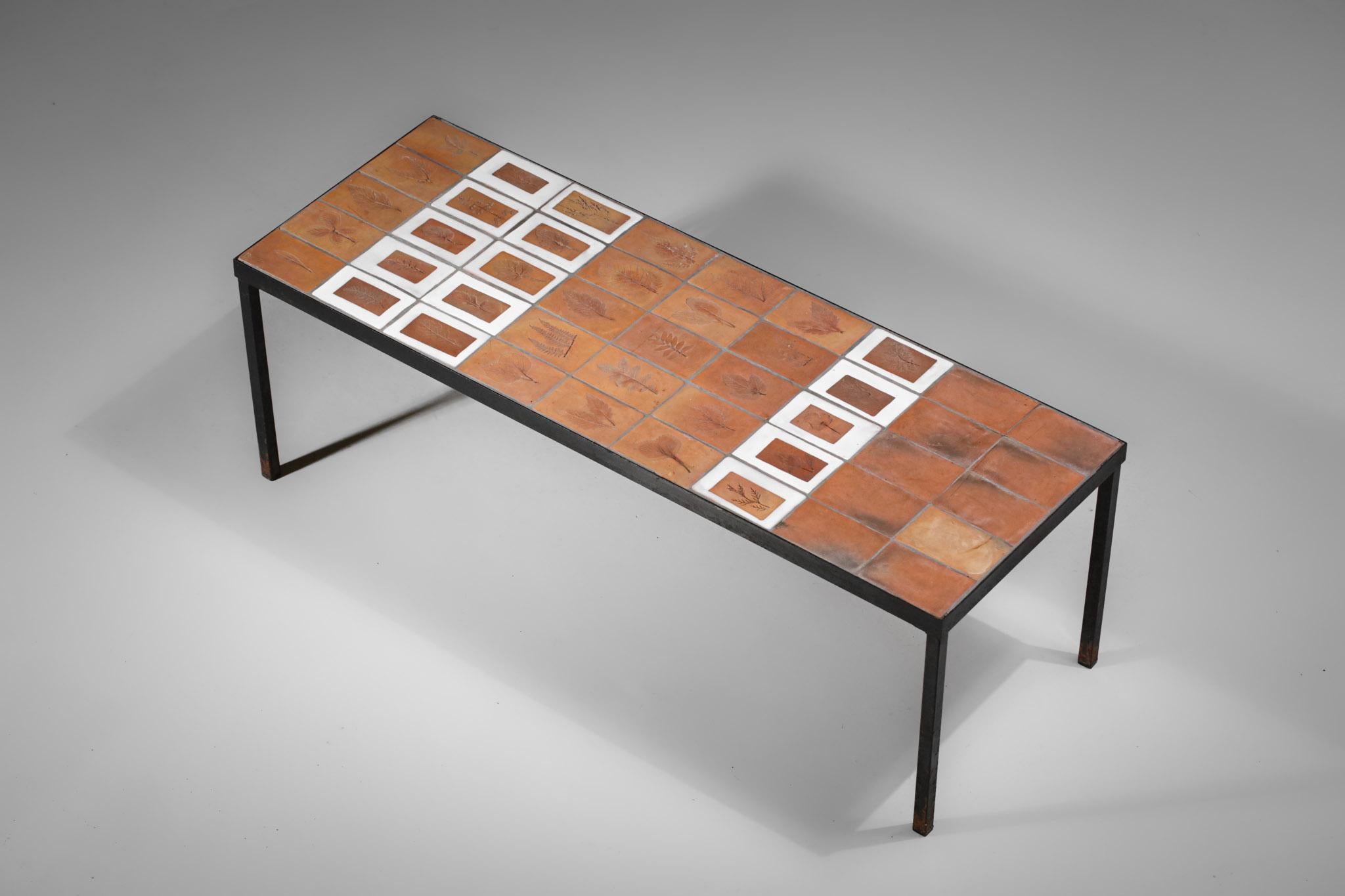 Metal and ceramic coffee table from the 60's by the French ceramist Roger Capron. The top is covered with brown and white glazed ceramic with inlays of the artist's typical 