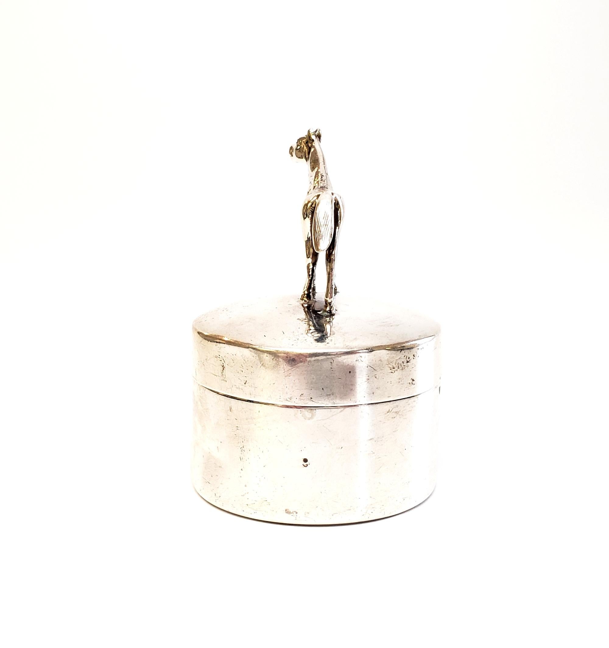 Antique sterling silver round box for postage stamps by Herbst & Wassall.

Featuring a figural horse and a gilt interior, this postage stamp box was designed by Herbst & Wassall, 1909-1940. Stamps can be dispensed from a roll thru the vertical
