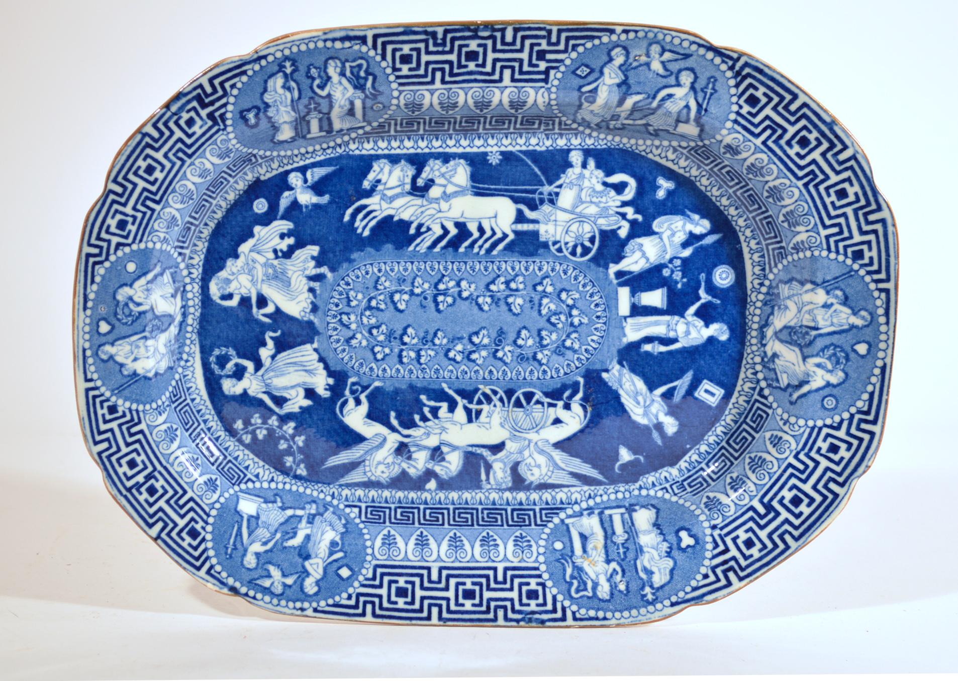 Herculaneum Neo-classical Greek pattern blue printed dish,
Early-19th century.

The Herculaneum pottery underglaze blue central pattern shows aseries of images encicling an oval panel with a leafy vine. There are two main images, one with winged
