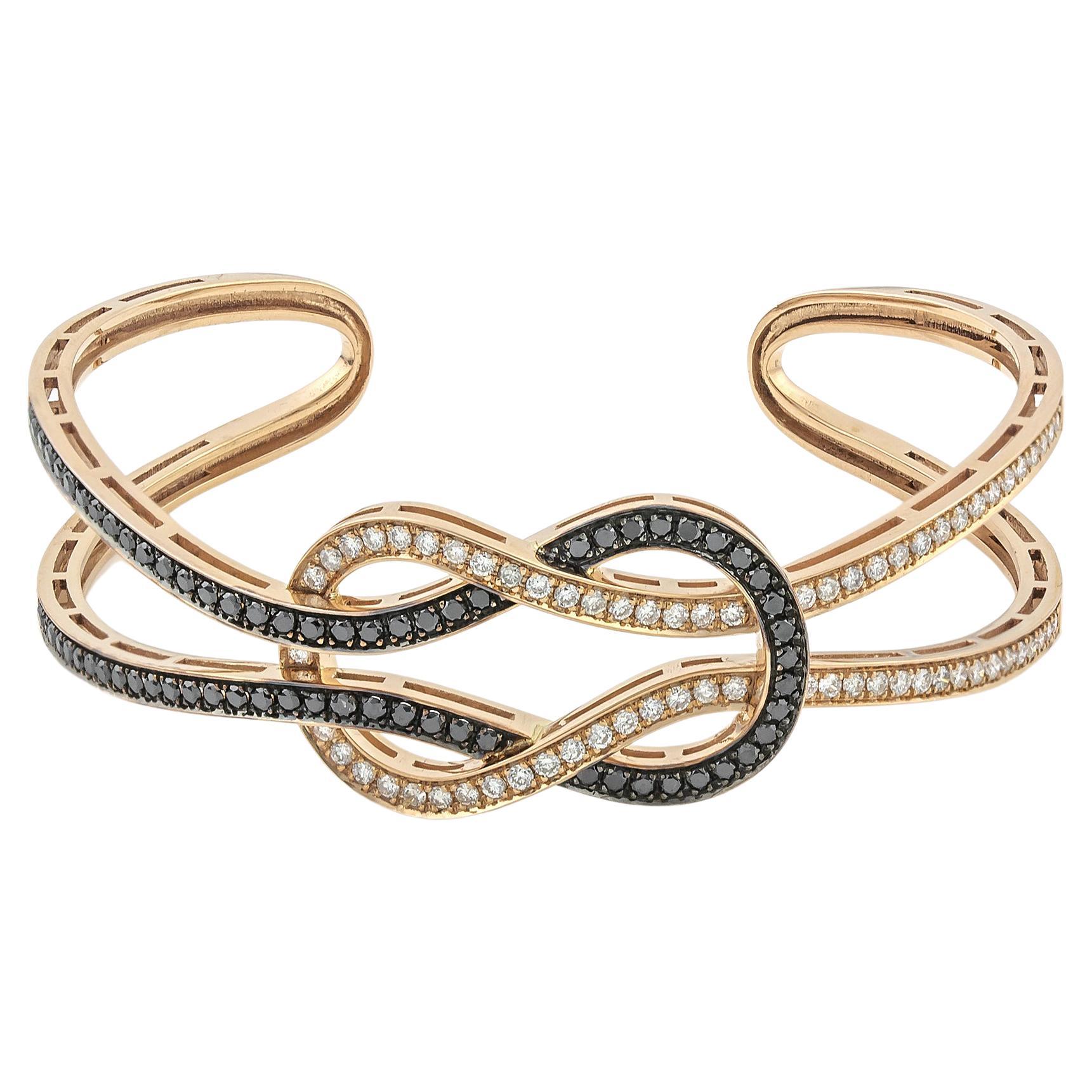 Hercules Knot or Love Knot Open Bangle cuff Bracelet in 18Kt Yellow Gold with Black & White Pave Diamonds.
Also known as the Marriage Knot, the Hercules Knot is a symbol that stands for undying love and commitment. This-One-of-a-kind Bangle Bracelet