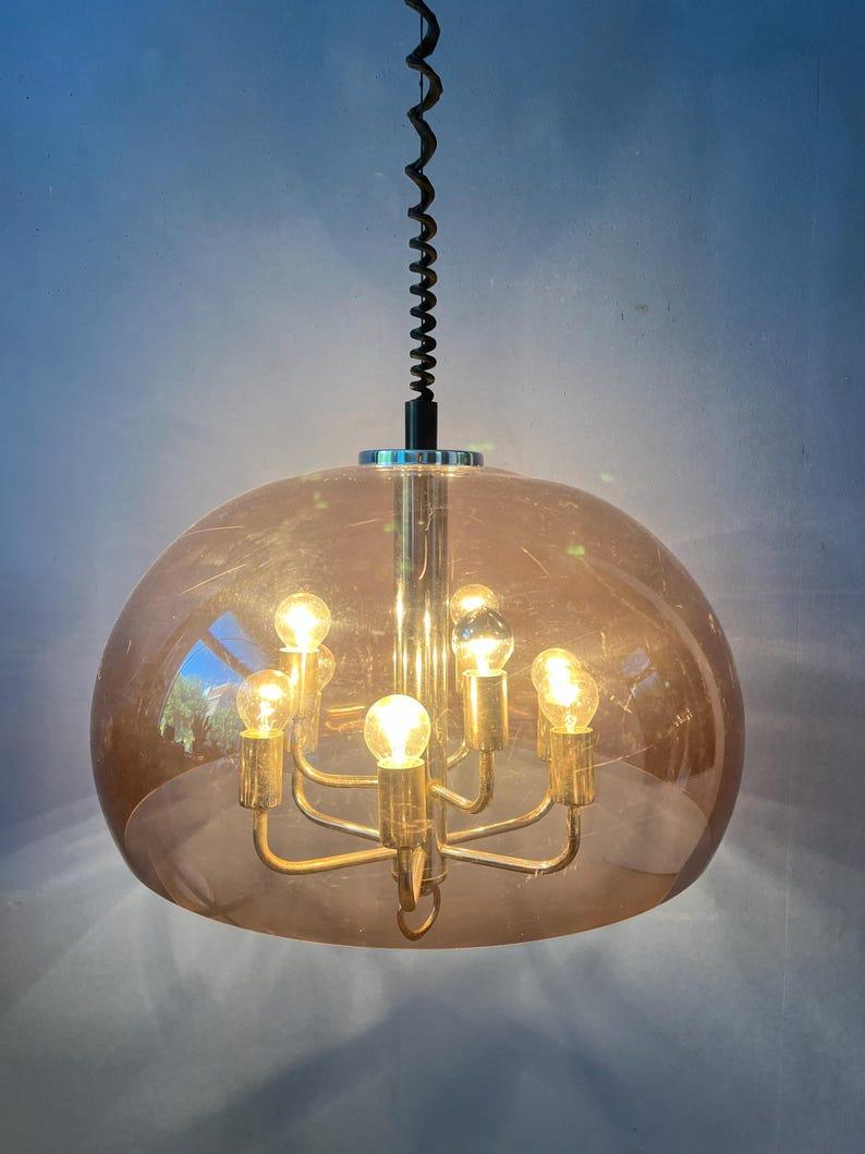 Lampada a sospensione a fungo viola trasparente di Herda, unica nel suo genere. Il paralume è realizzato in vetro acrilico trasparente, ma ha un riflesso viola. All'interno c'è un lampadario cromato con 9 fonti di luce. L'altezza della lampada può