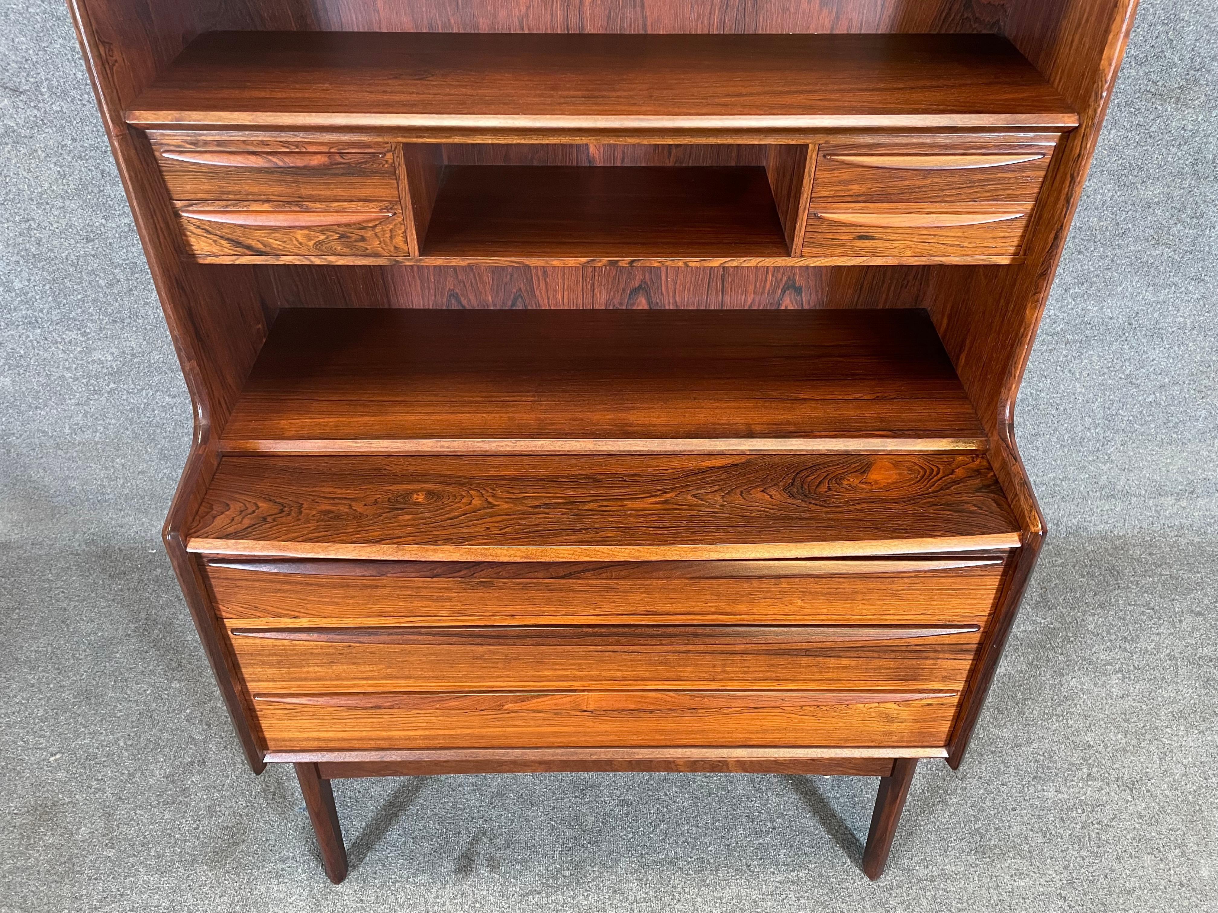 Here is a beautiful Scandinavian modern secretary-desk-bookcase manufactured in Denmark in the 1960's.
This exquisite piece, recently imported from Europe to California before its refinishing, features a vibrant wood grain, a bank of three large
