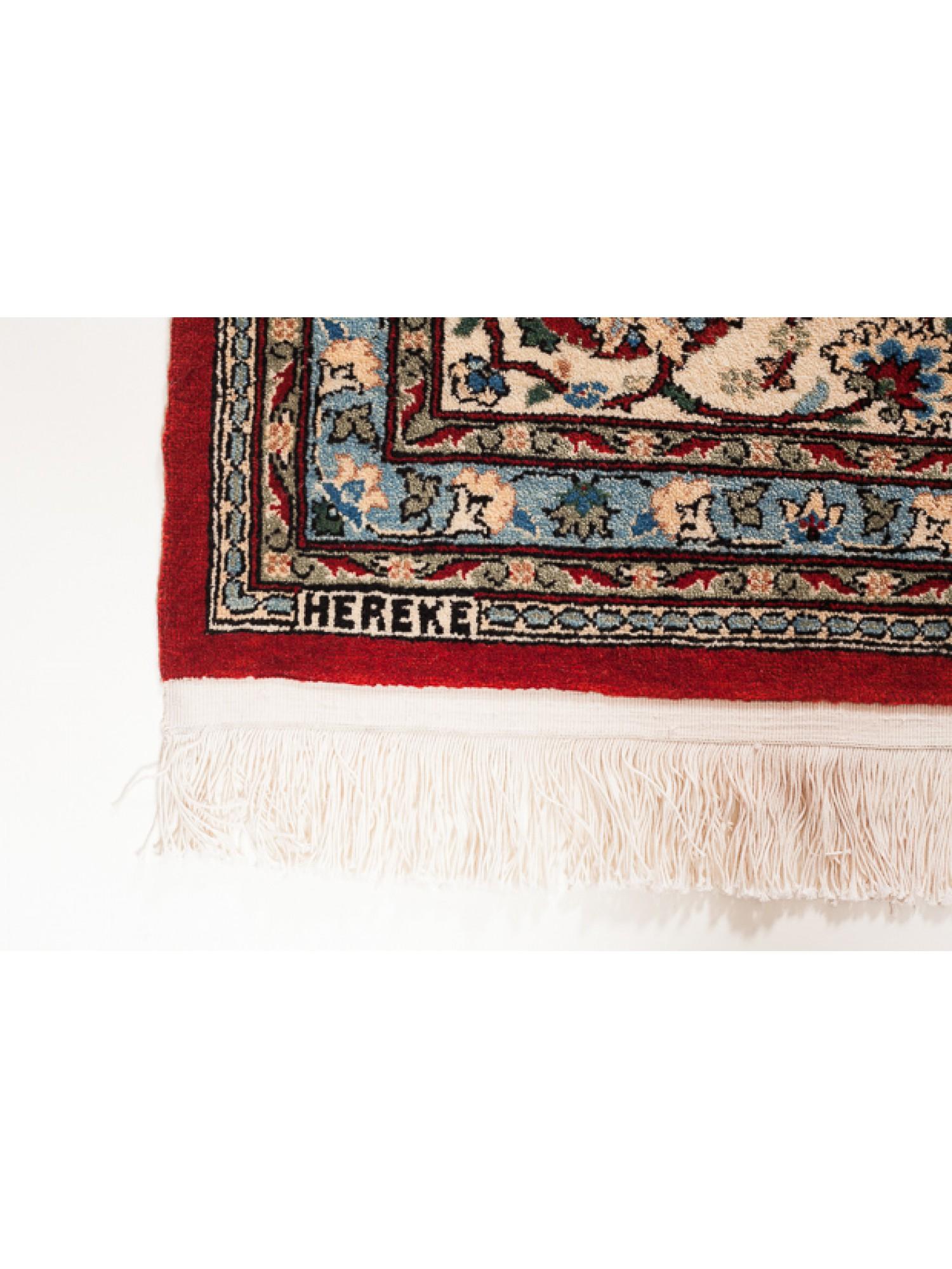 Ce tapis unique en laine de Hereke compte parmi les tapis de la plus haute qualité de l'atelier Hereke. Il y a un treillis de fleurs sur un fond rouge profond, avec la finesse du tissage, l'utilisation de la couleur, et le design élégant et