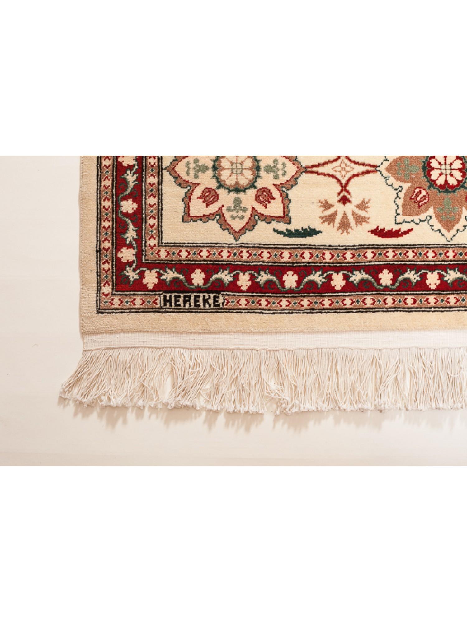 This unique Wool Hereke Carpet is among the highest-quality carpets in the Hereke workshop. There are traditional Ottoman Empire carnations and tulip design rows on a white background with the fineness of the weave, the use of color, and the elegant