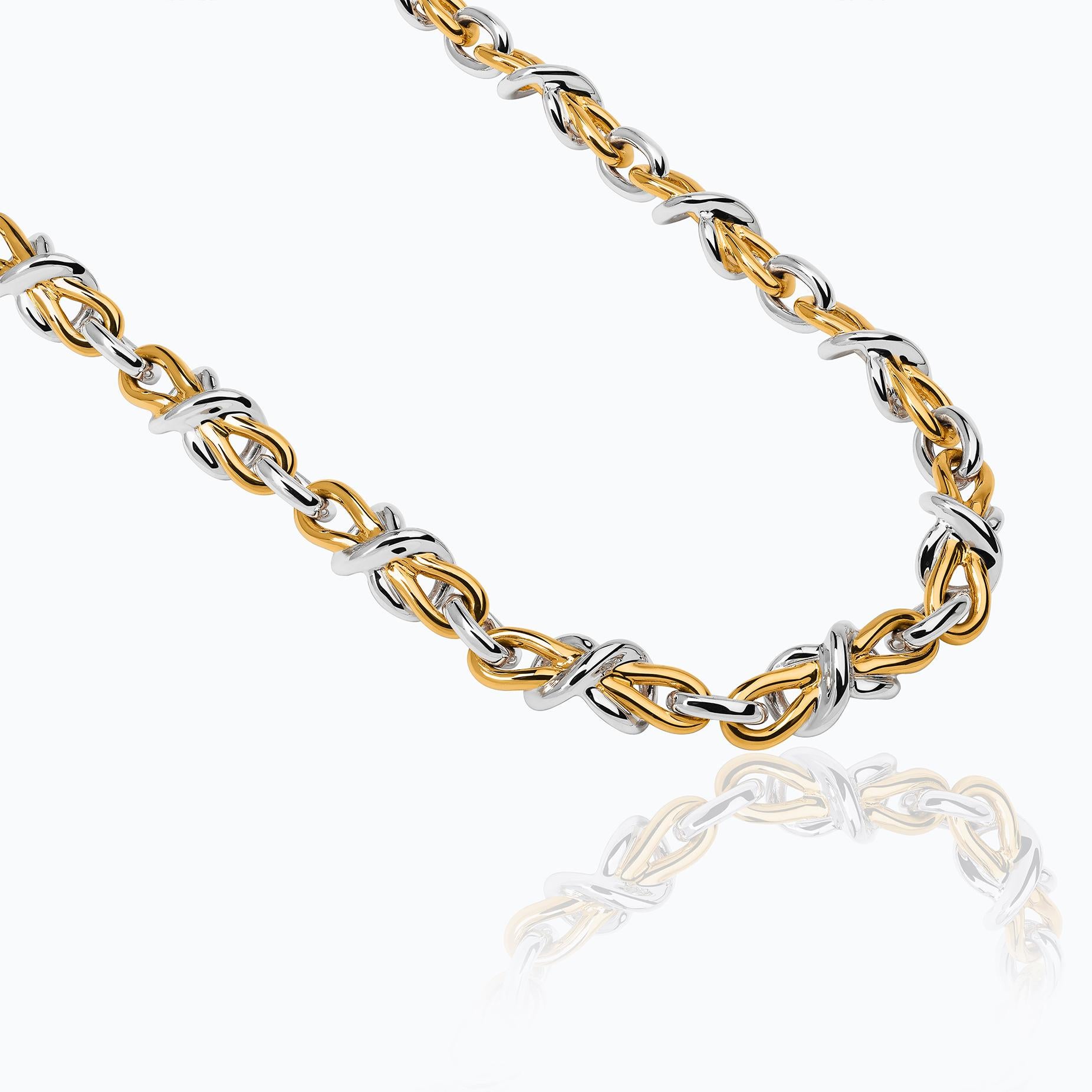 The Herencia Bow Choker is part of a numbered limited edition of 80 units, made of sterling silver with 23 karat yellow gold vermeil. The choker is made up of a succession of silver links, interspersed with sculptural motifs inspired by the eternal