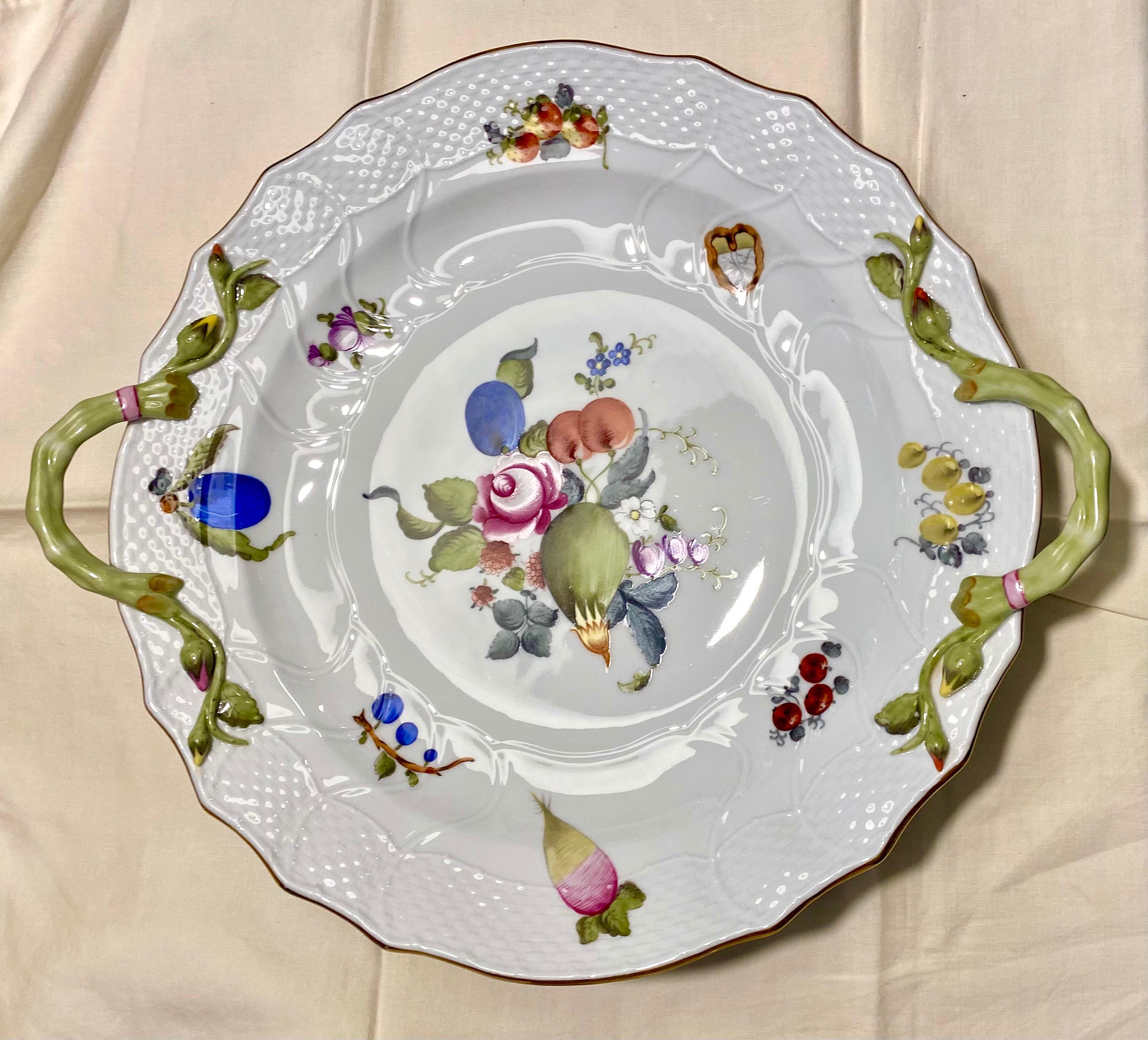 A beautiful Herend hand painted porcelain two handled platter or chop plate in the fruit and flower patter. Since its introduction in the 1860s this pattern, with its beautiful compositions of fruits and flowers, has been favored by many royal