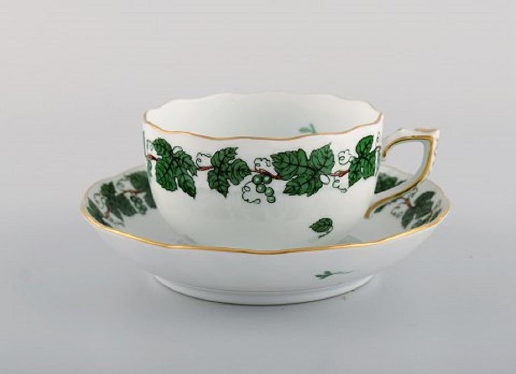 Herend green grape & leaf vine tea service for eight people in hand-painted porcelain. Mid-20th century.
Consisting of eight teacups with saucers and eight cake plates.
The teacup measures: 9 x 5.5 cm.
Saucer diameter: 13.8 cm.
Plate diameter: