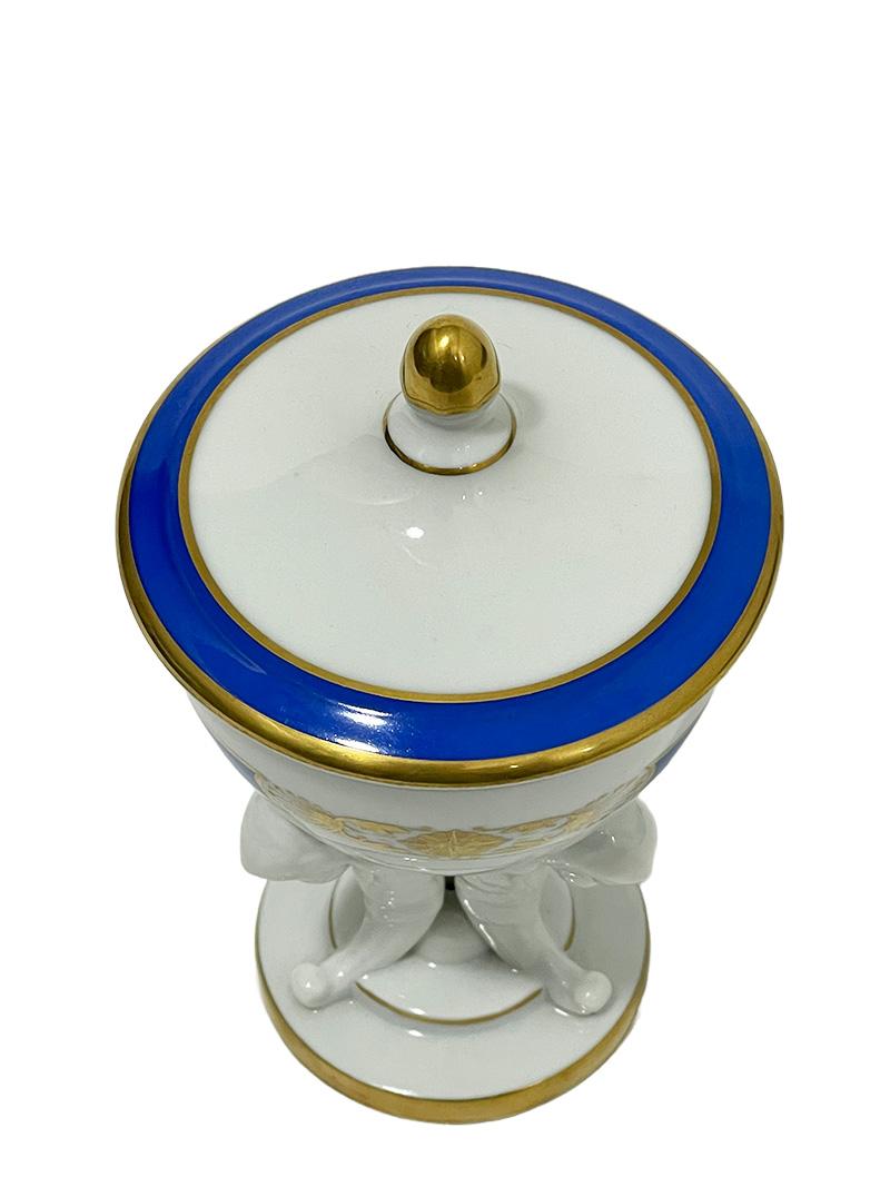 Herend Hungary porcelain D'or Blue small lidded vase, 1960s

A Herend Hungary porcelain lidded vase (trinket box) in Empire style with the D'or Blue pattern. 
A small porcelain vase, raised on a round foot with three angel figurines and empire style