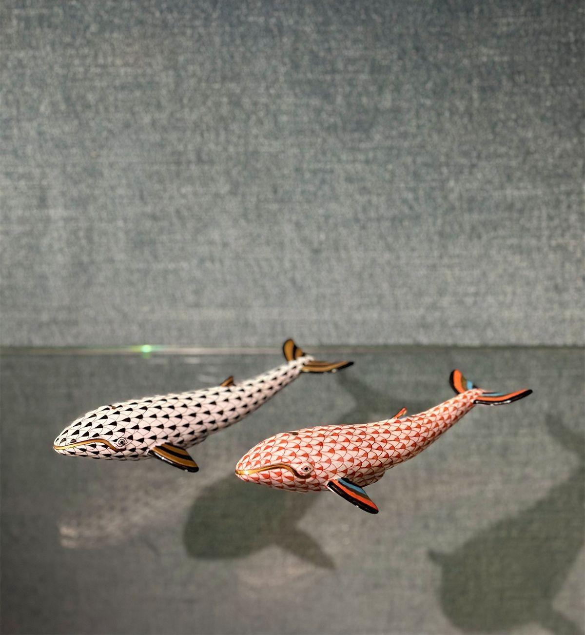 Set of five figurines depicting sea animals: two whales, two fishes and a coral piece with a group of fish. Each figurine is decorated with the iconic fishnet design; each colored different combining pink, yellow, blue, green and other tones. They