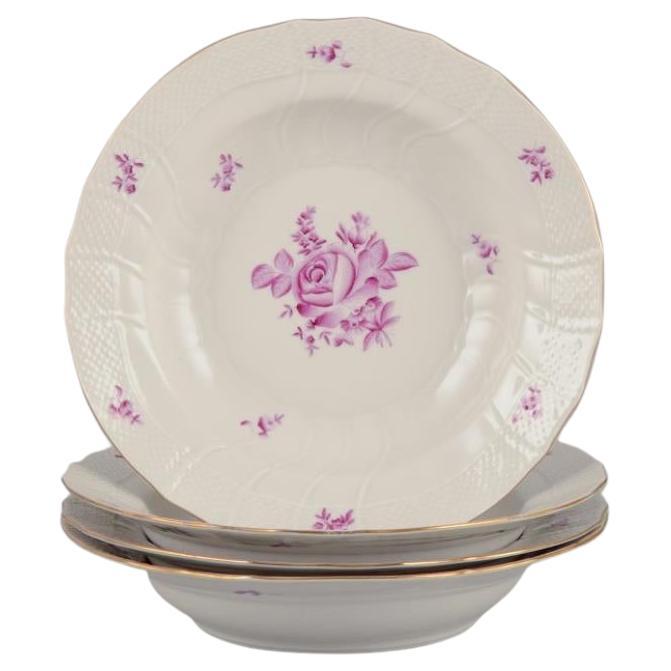 Herend, Hungría. Juego de cuatro platos hondos con motivos florales morados