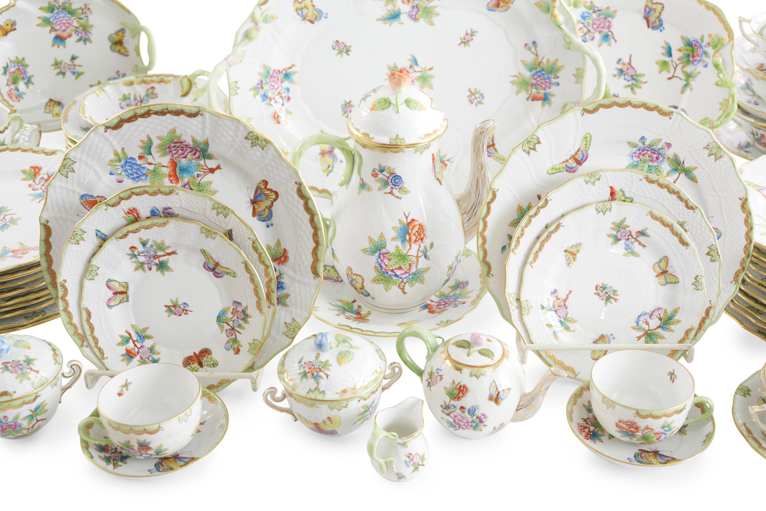 Herend porcelain dinnerware service for twelve people with serving pieces. Each piece is beautifully painted with butterflies and flowers with gilt gold trim details. Each piece is in great condition. Service is barely used, minor wear. Maker's mark